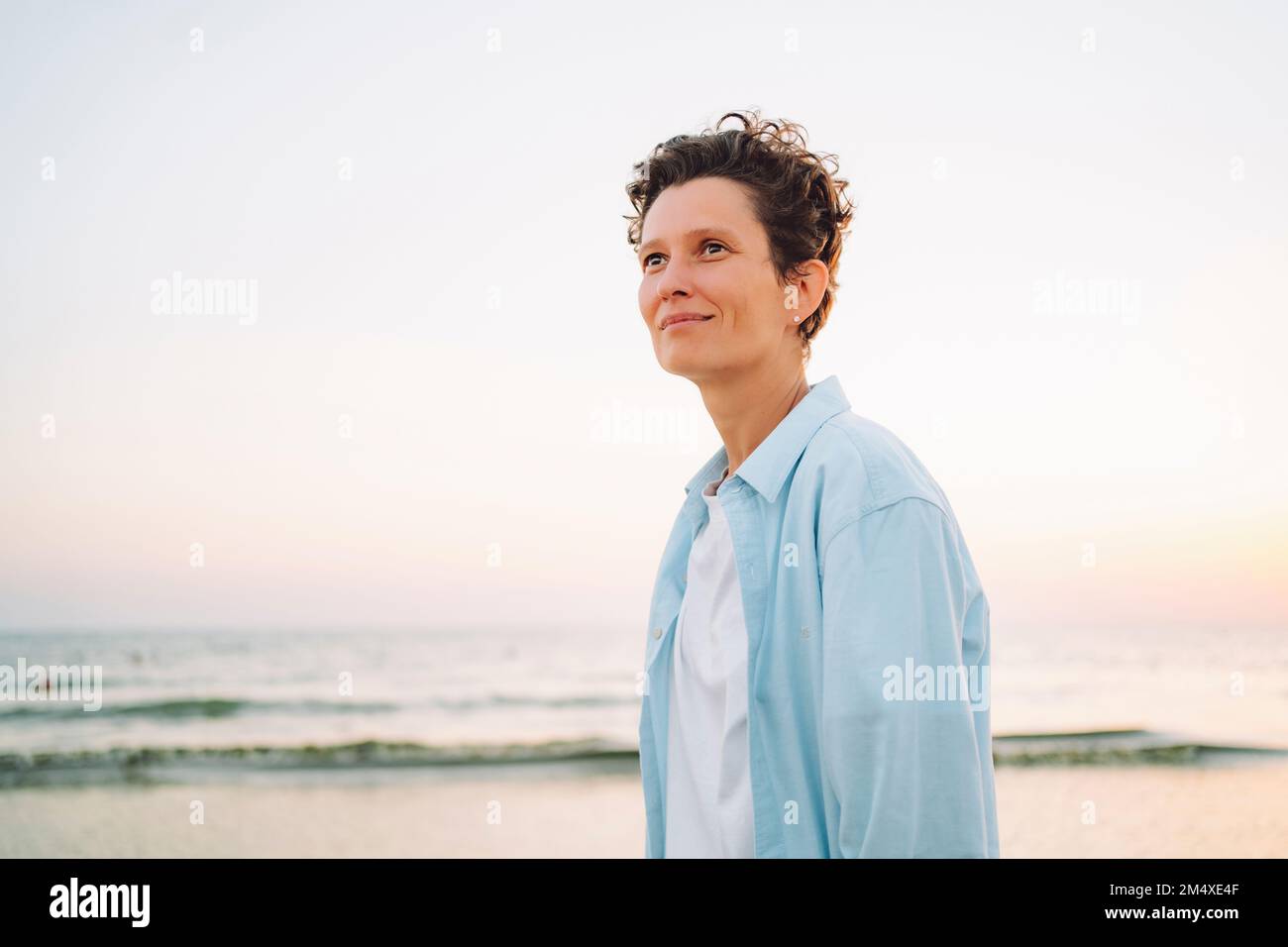 Thoughtful androgynous woman standing at beach Stock Photo