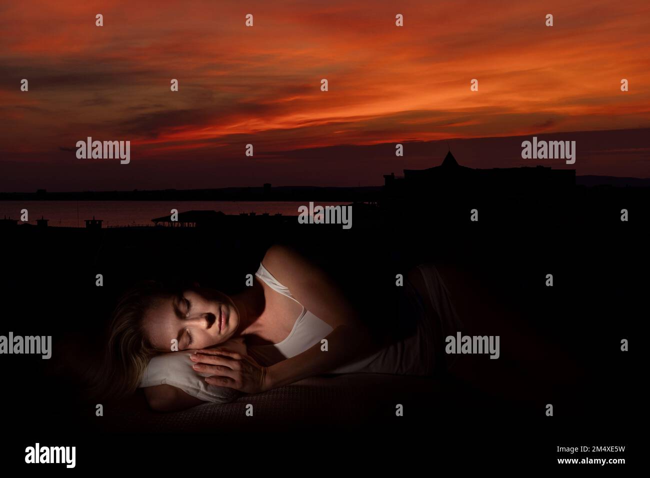 Woman with eyes closed sleeping at sunset Stock Photo