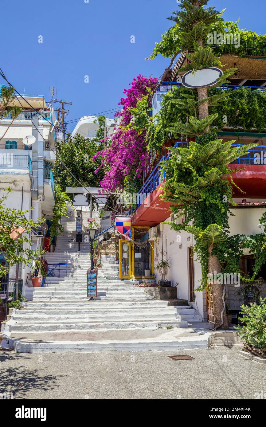 Greece, Crete, Agia Galini, Balcony filled with potted plants overlooking alley steps in summer Stock Photo