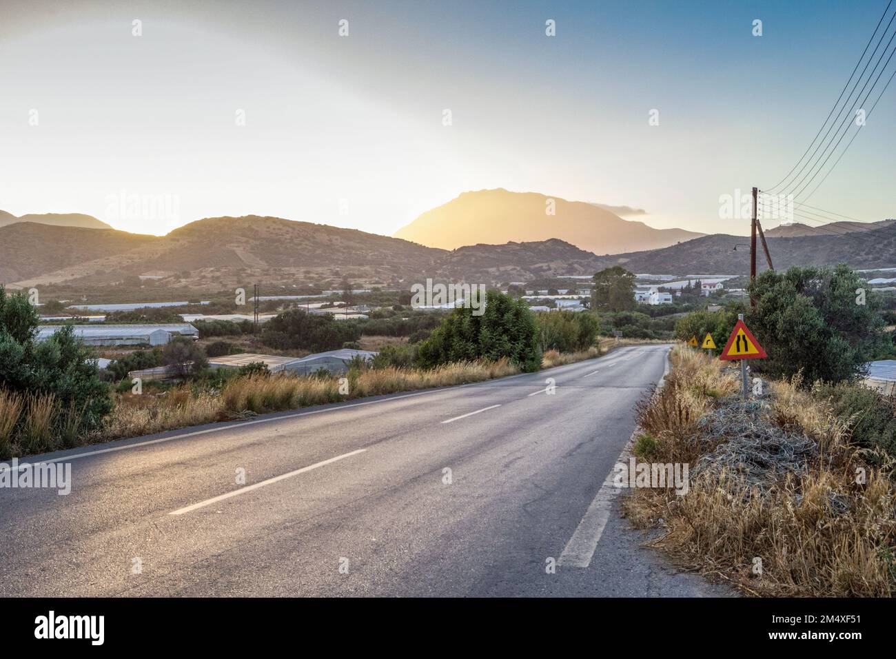 Greece, Crete, Agia Galini, Empty country road at sunset Stock Photo