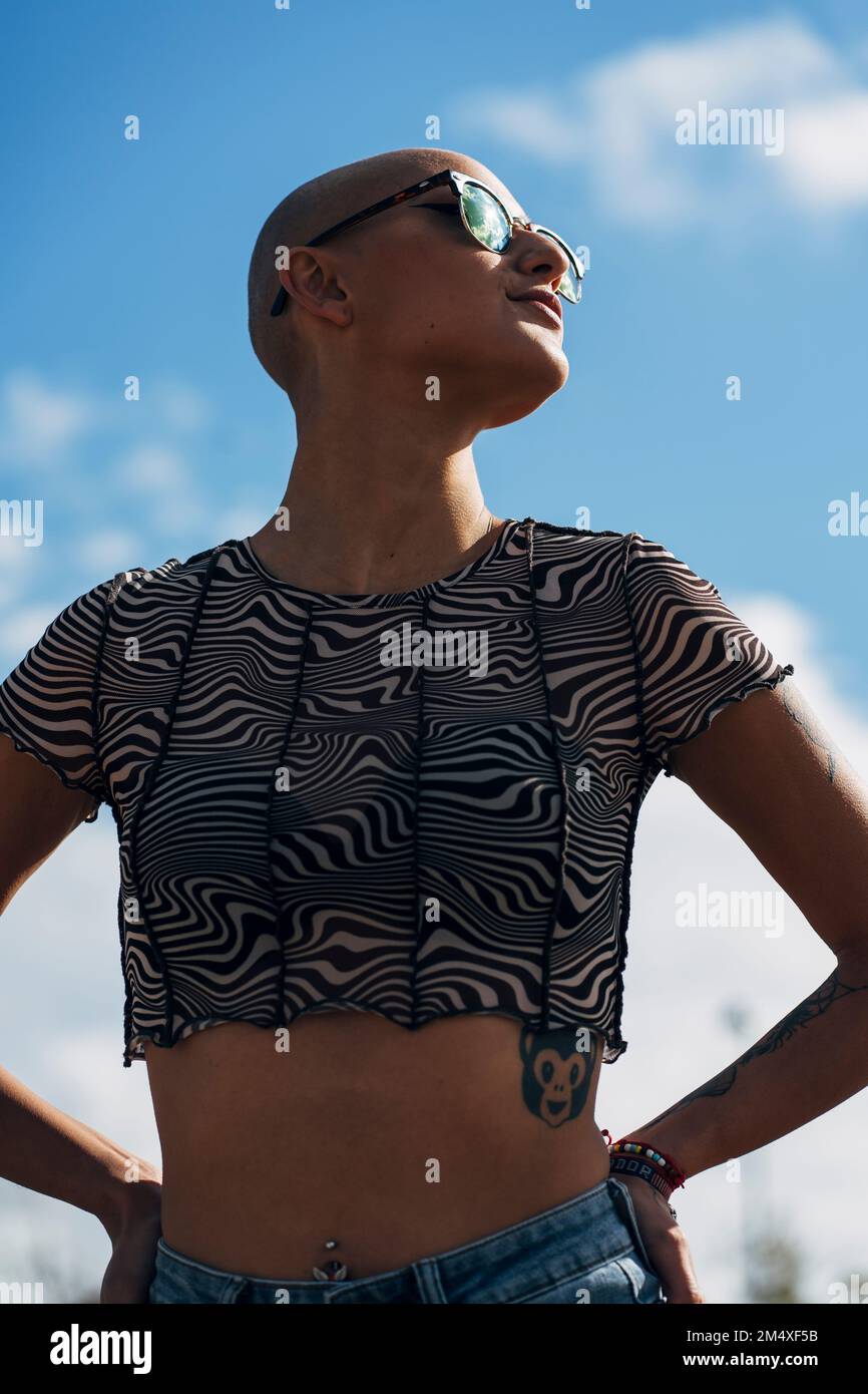 Woman with hand on hip standing in front of sky Stock Photo