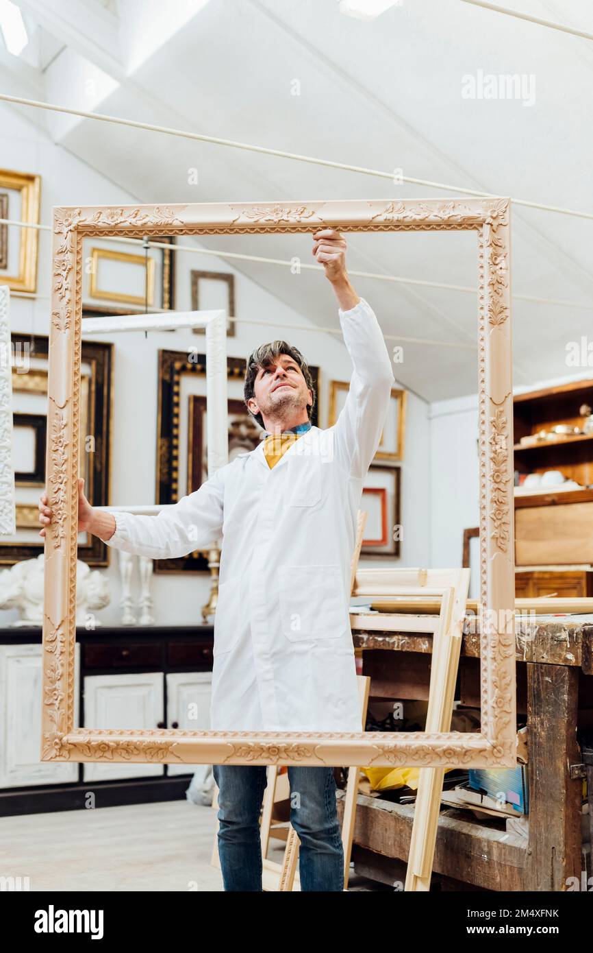 Woodworker working with frame in studio Stock Photo