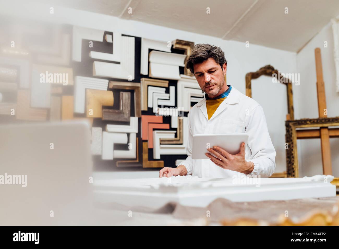 Mature craftsman using tablet PC in workshop Stock Photo