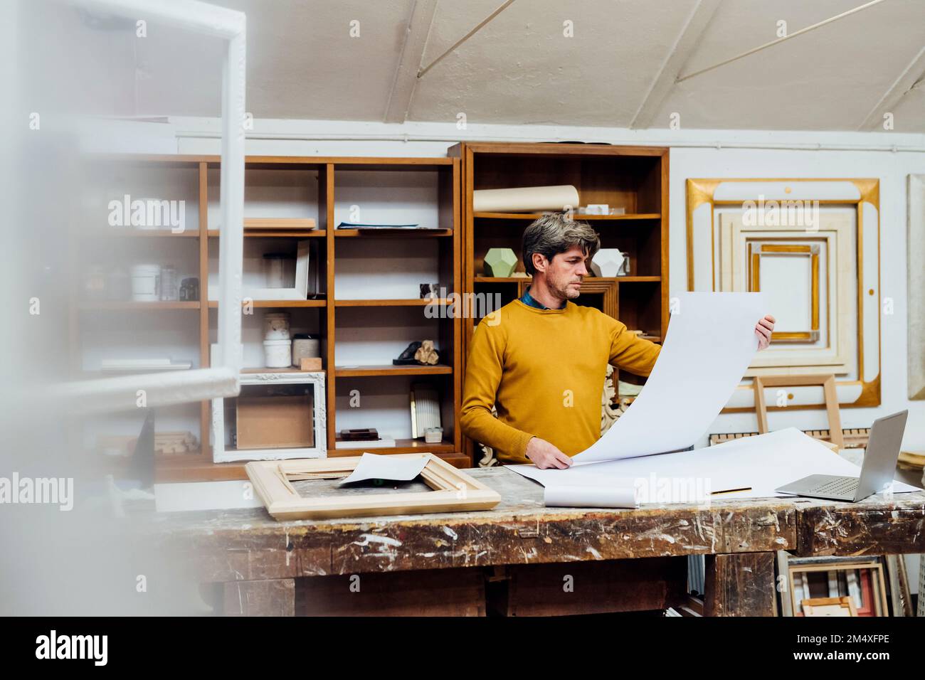 Craftsman looking at blueprint in studio Stock Photo - Alamy