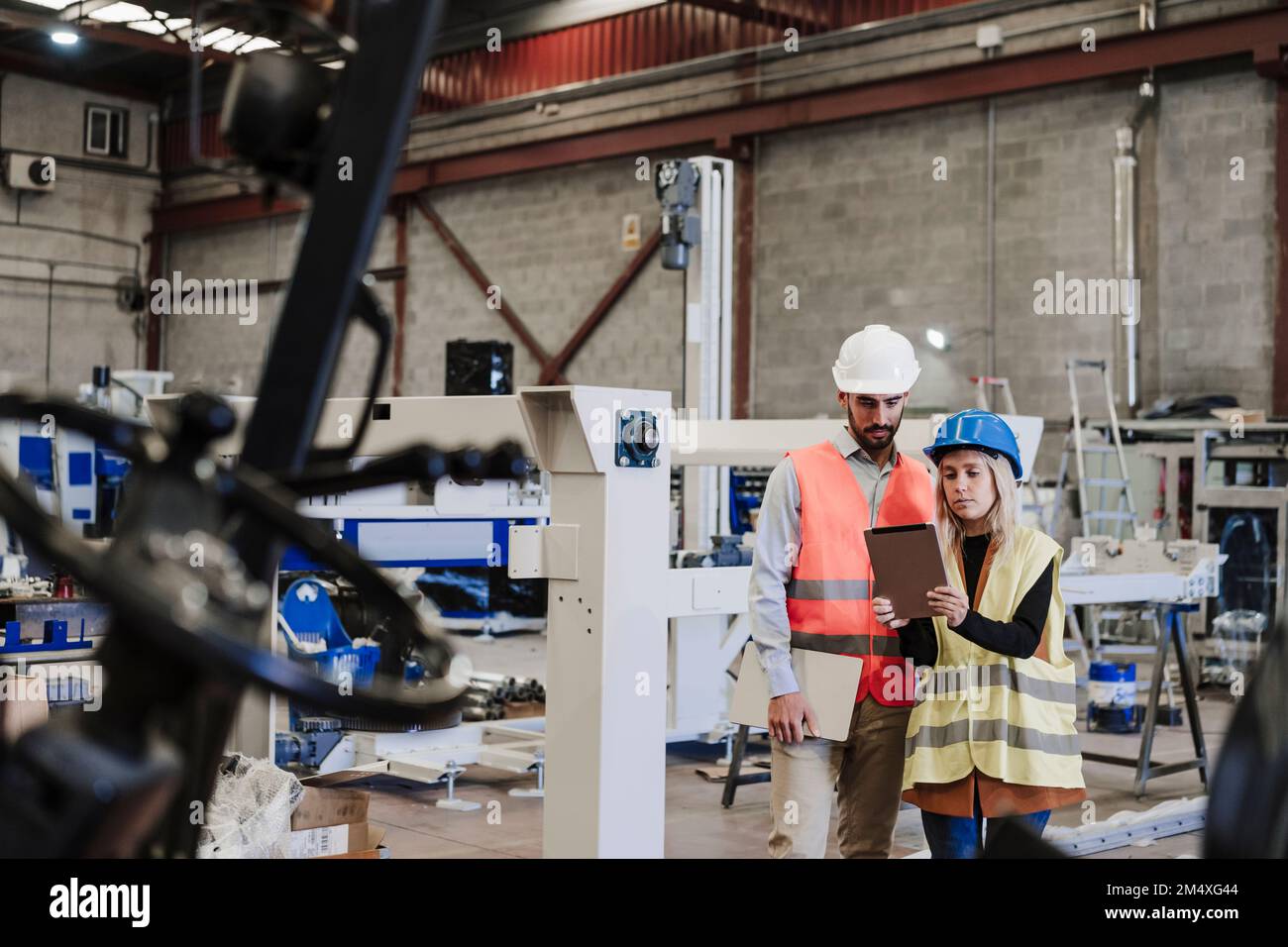 Engineer with colleague using tablet computer at industry Stock Photo