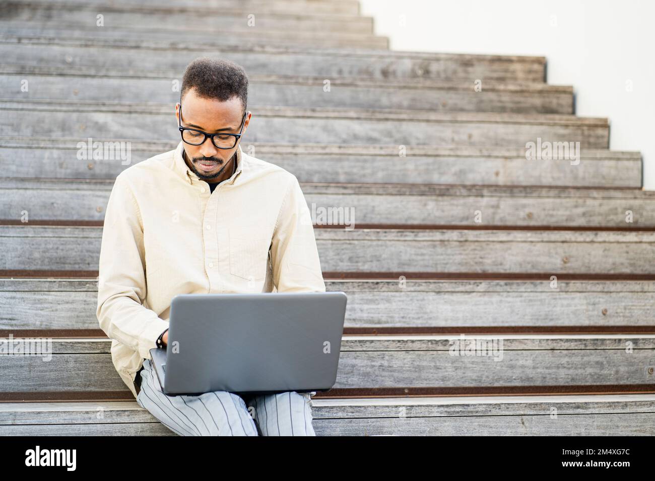 Freelancer using laptop sitting on steps Stock Photo