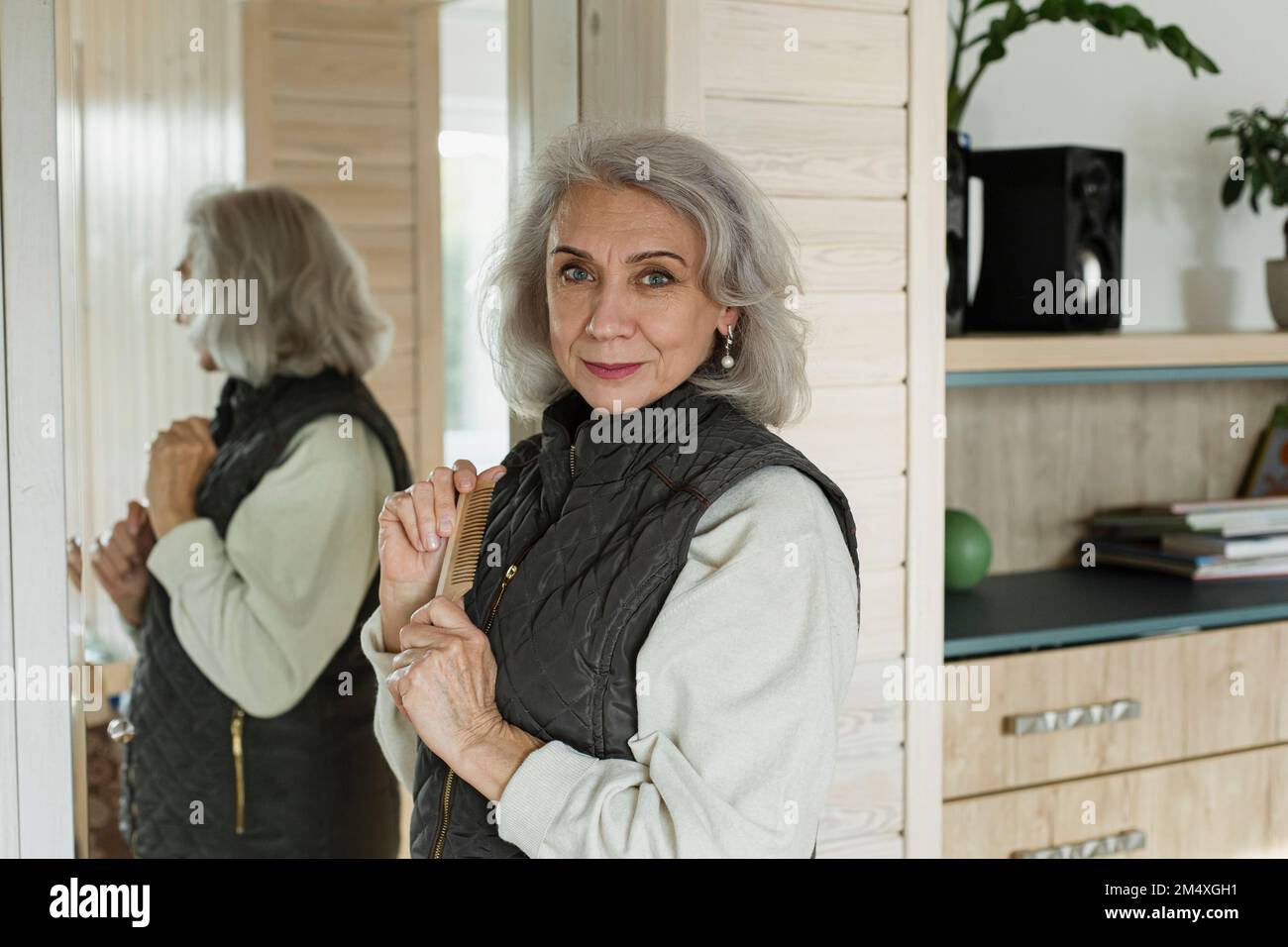 Portrait of confident senior woman in front of mirror at home Stock Photo