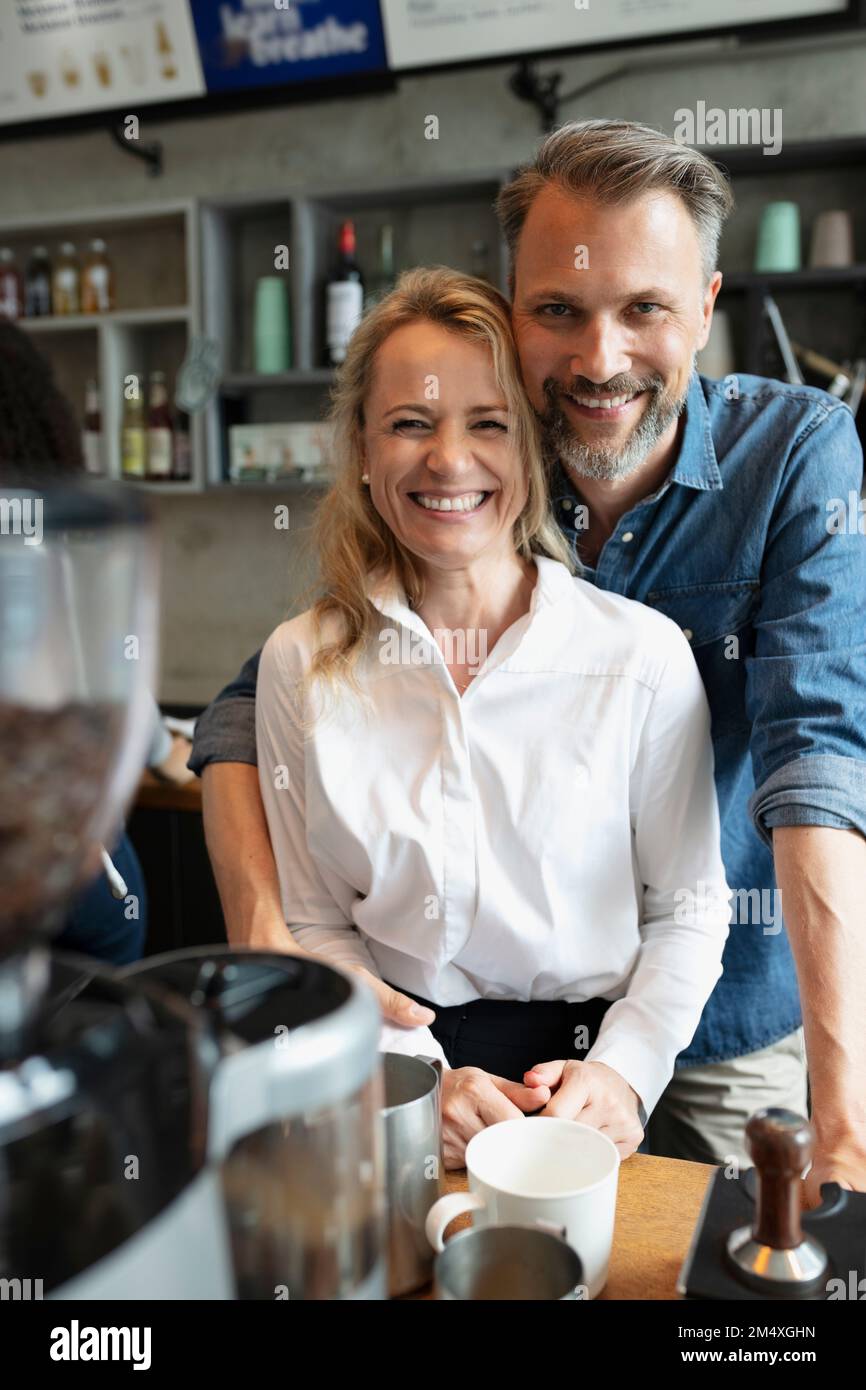 Happy coffee shop owner standing together at counter Stock Photo Alamy