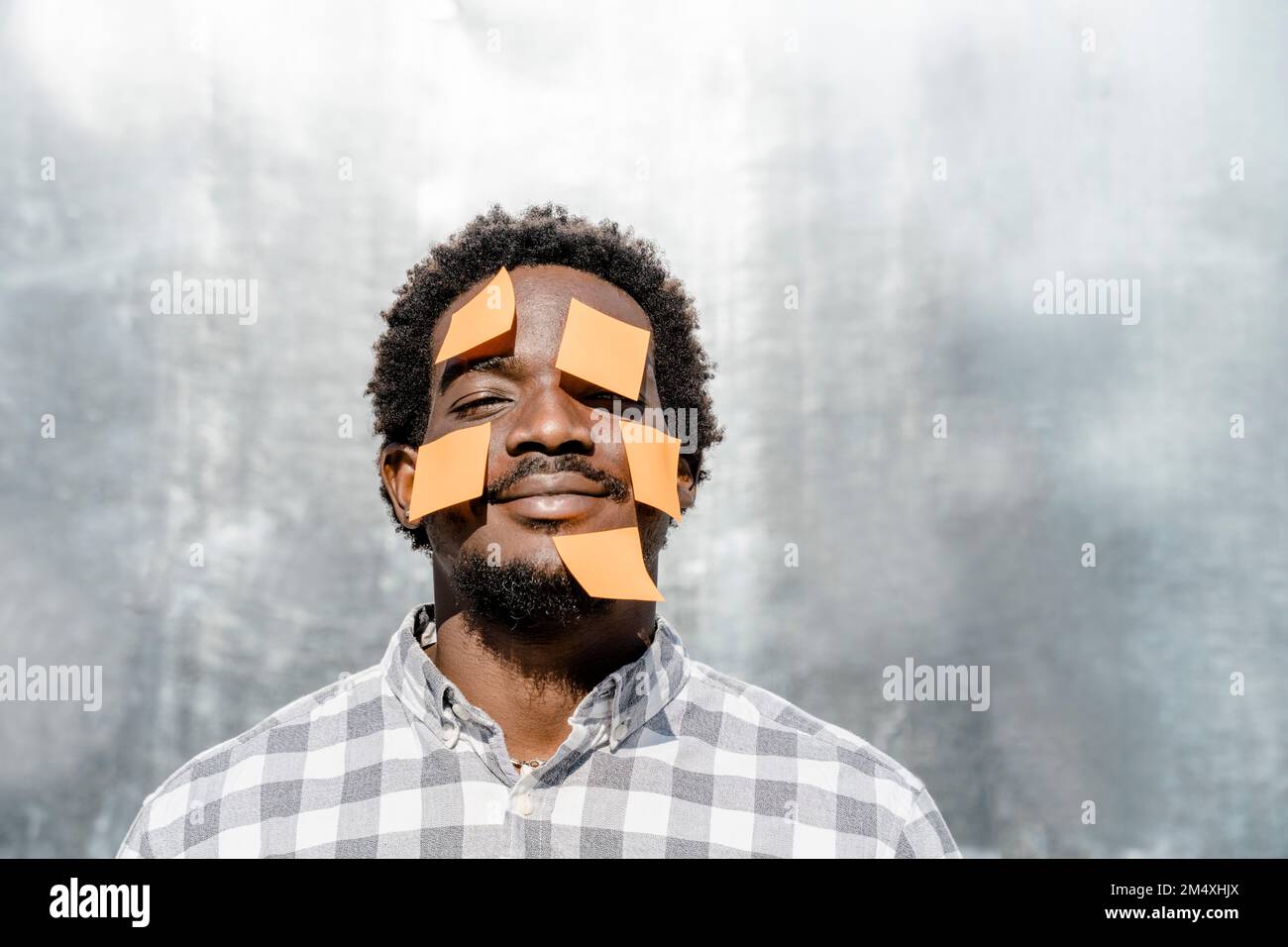 Smiling man with blank adhesive notes on face Stock Photo - Alamy