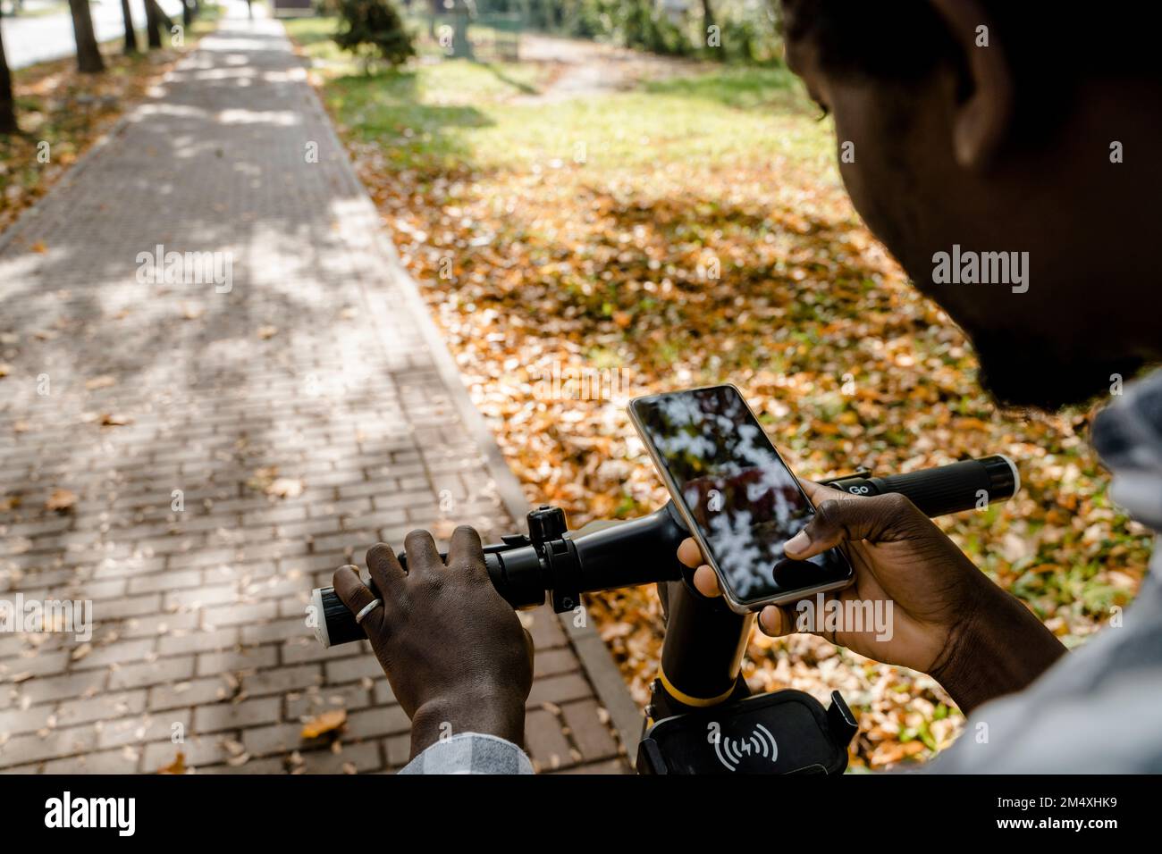 Man with push scooter using app on smart phone Stock Photo