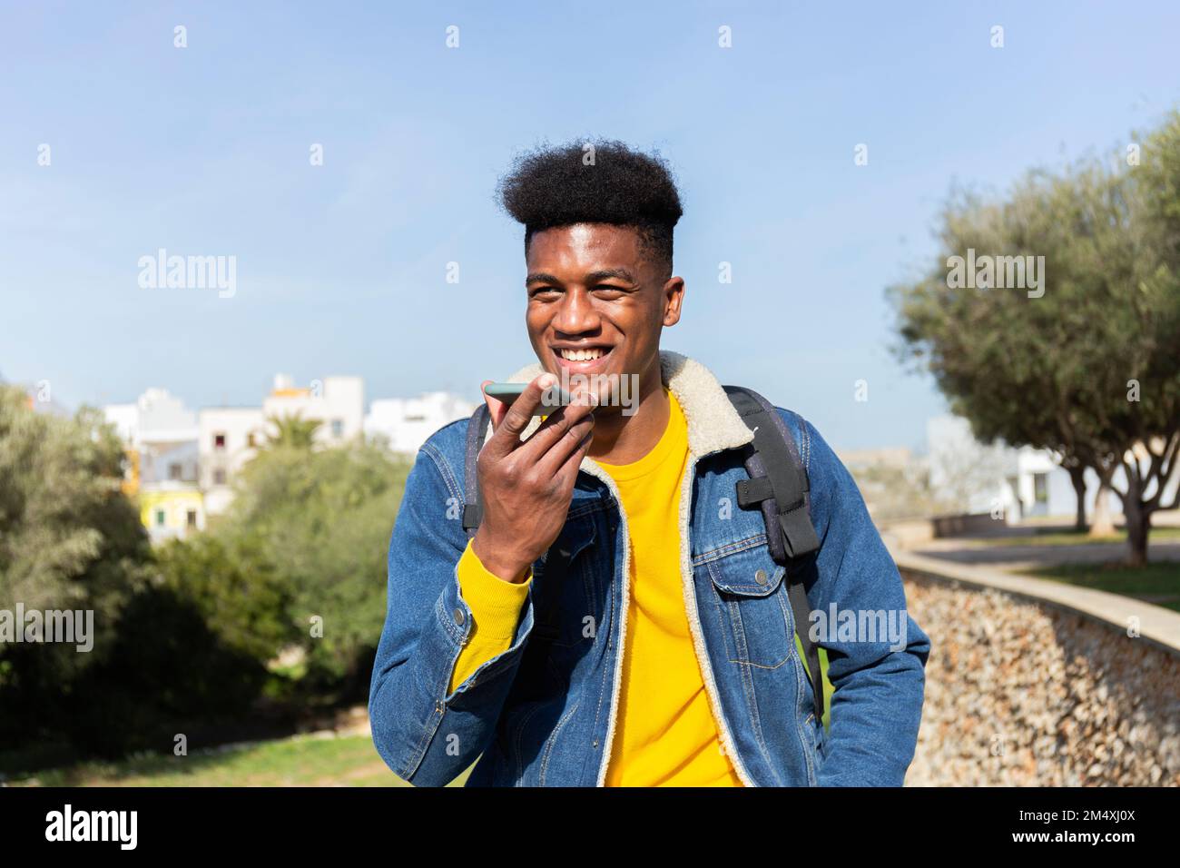 Smiling man talking on speaker phone Stock Photo