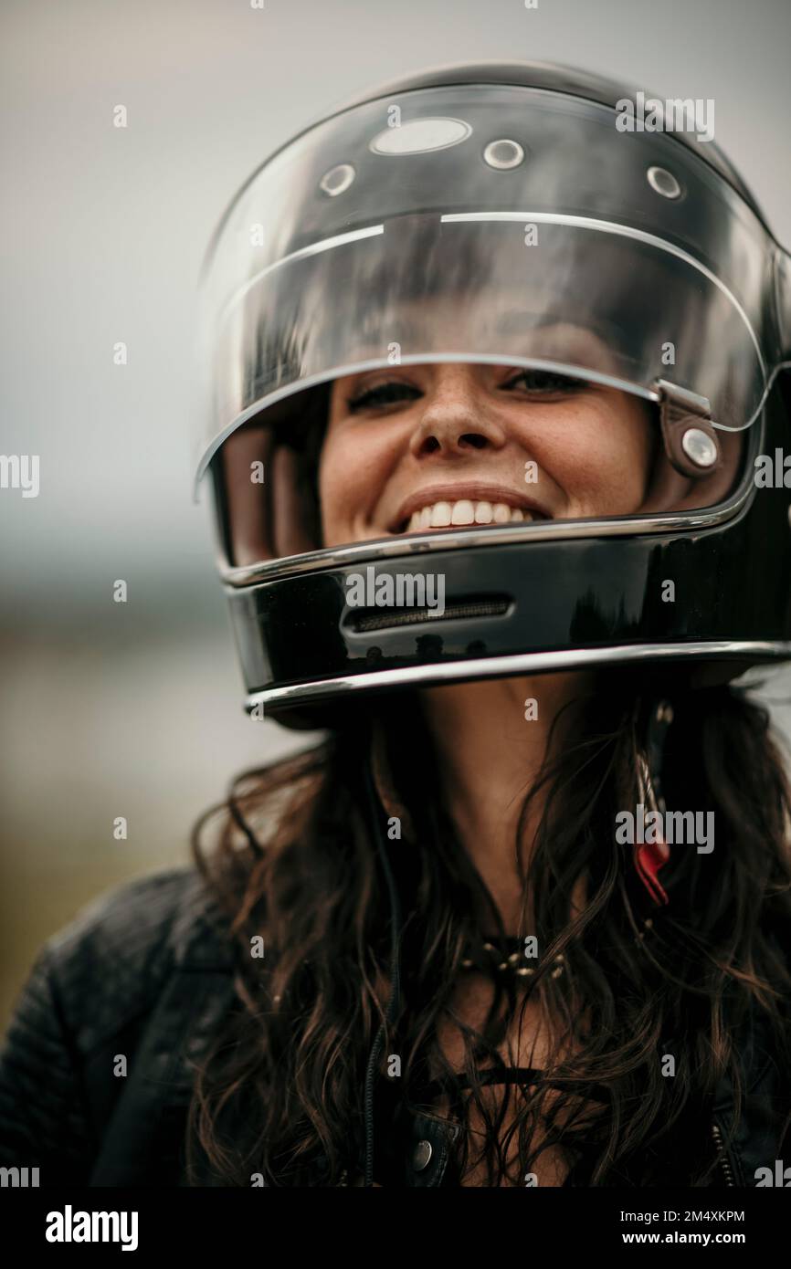 Happy woman with long hair wearing helmet Stock Photo - Alamy