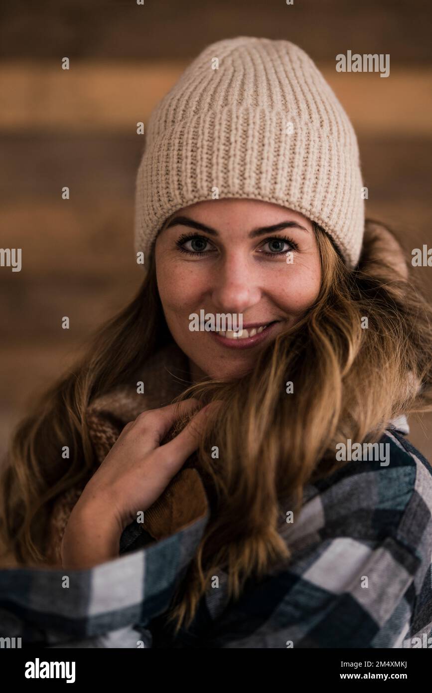 Smiling beautiful blond woman wearing knit hat Stock Photo