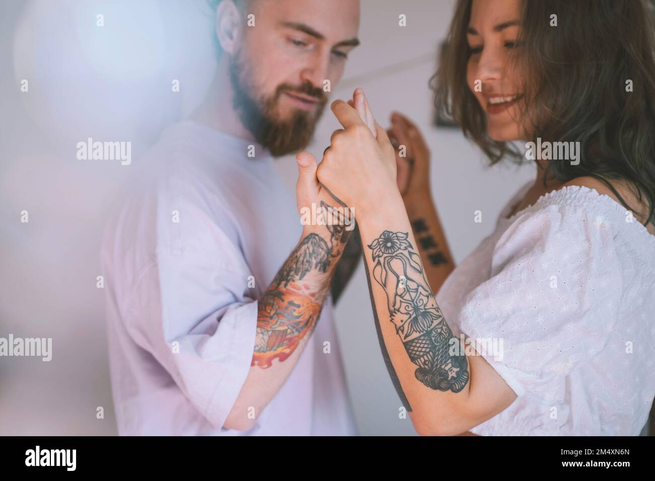 Happy hipster couple with tattoo on hands dancing together Stock Photo