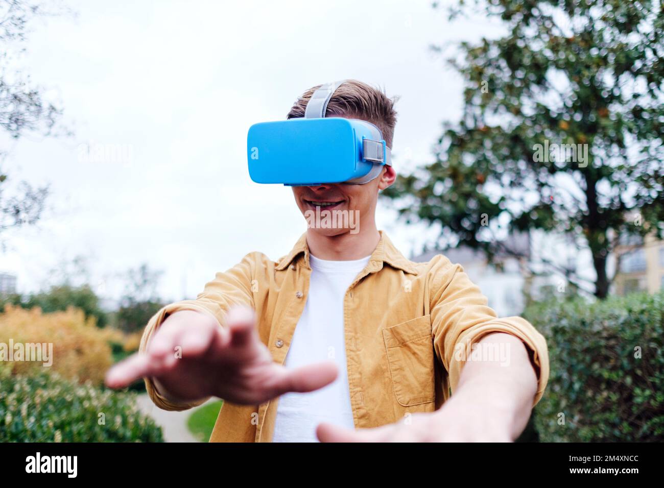 Smiling young man wearing virtual reality headset Stock Photo