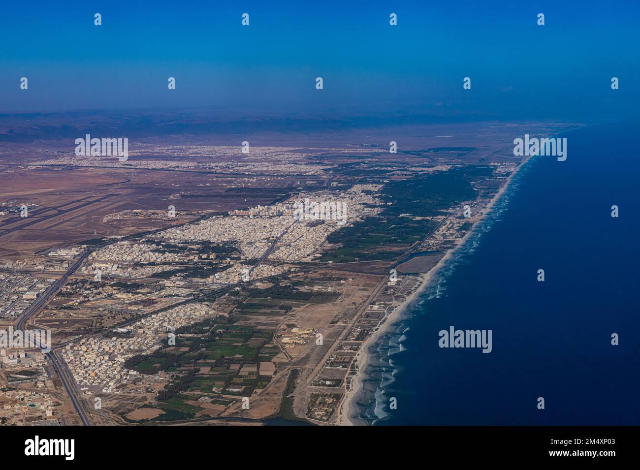 Oman, Dhofar Governorate, Salalah, Aerial view of desert city and coastline of Persian Gulf Stock Photo
