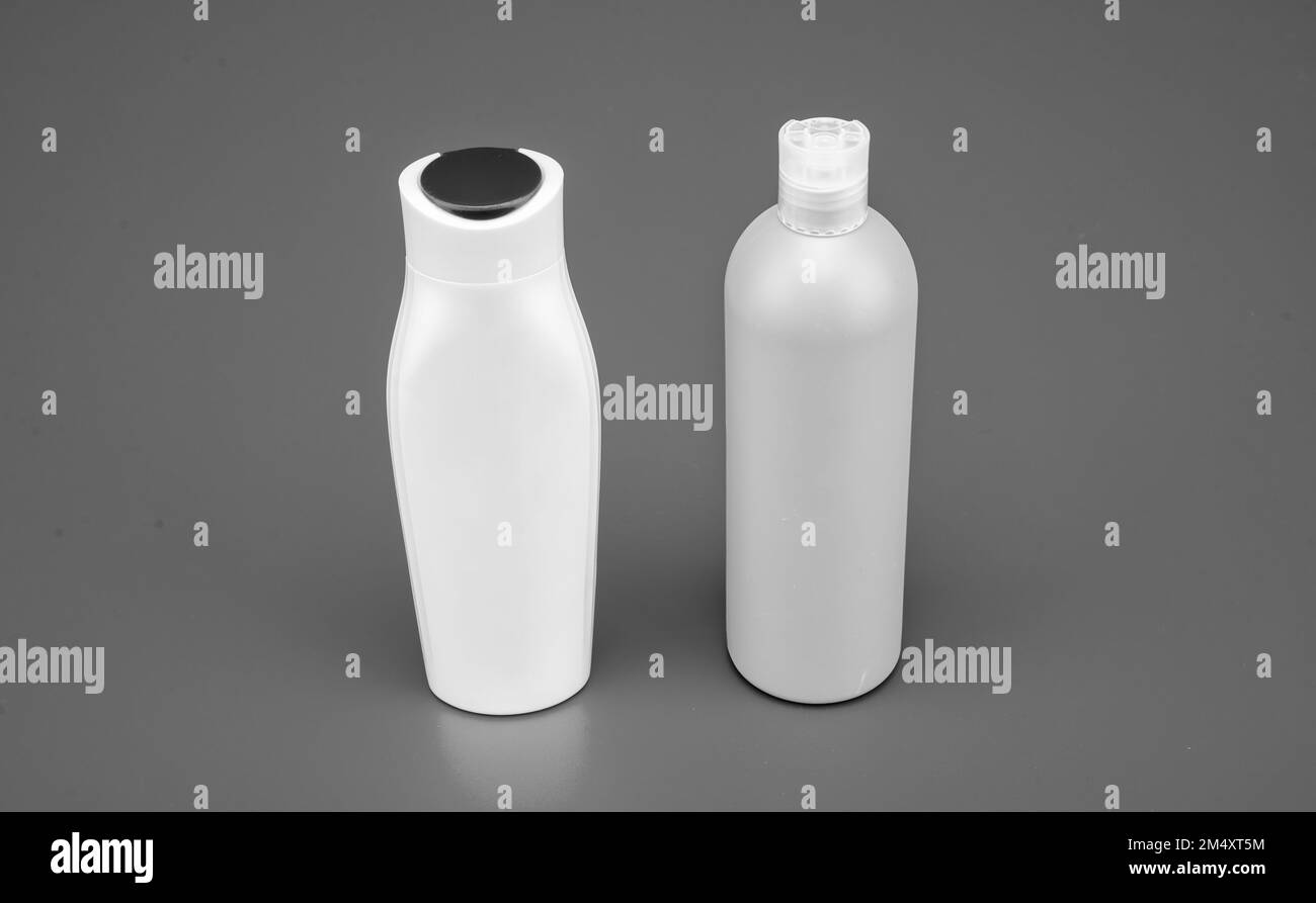 HDPE blue background. Refillable shampoo and conditioner bottles. Plastic cosmetic packaging bottles Stock Photo