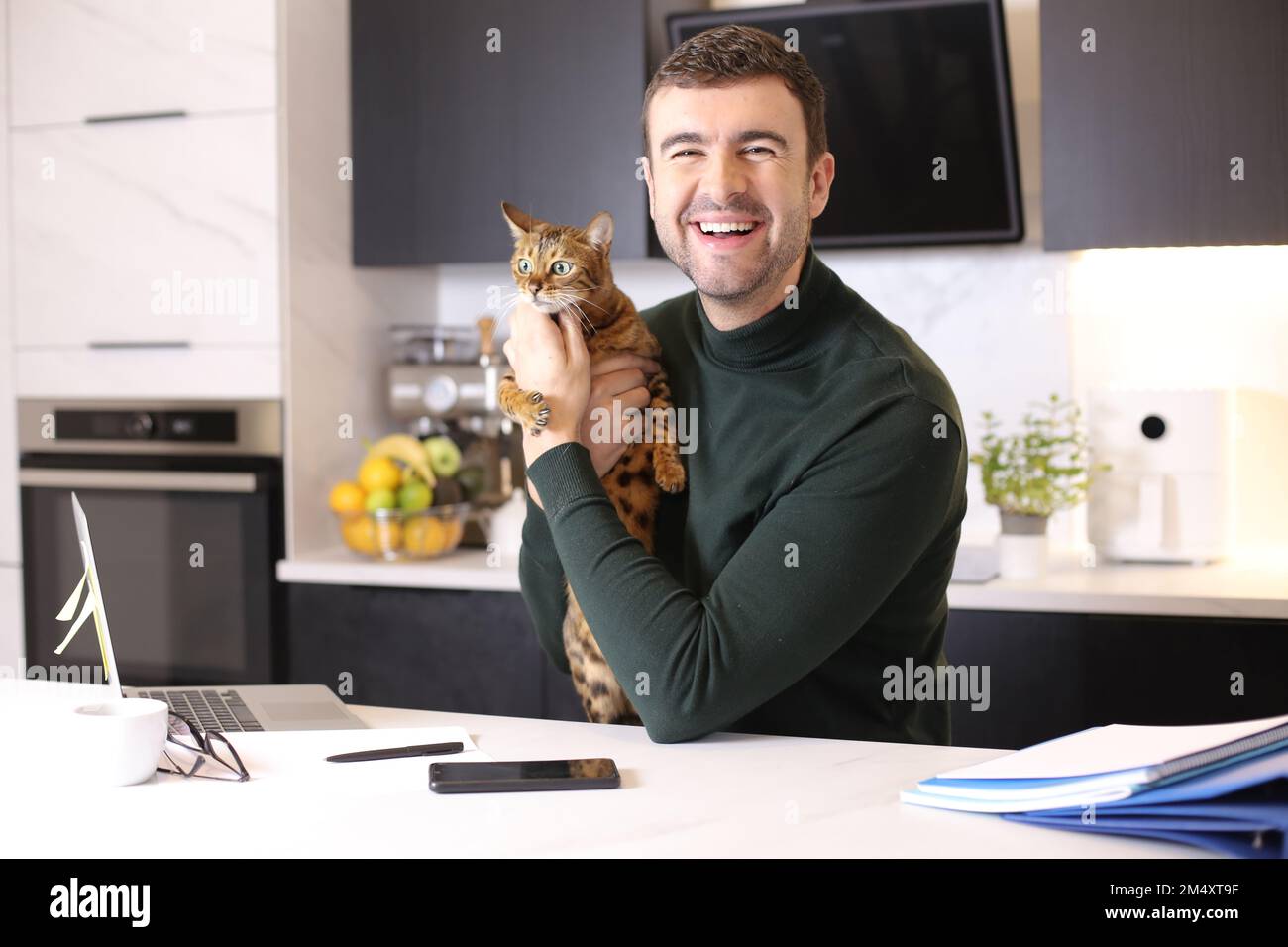 Attractive man working from home with his cat Stock Photo