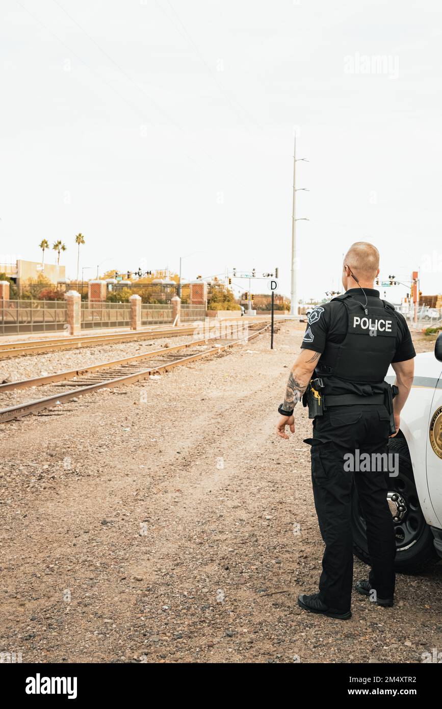 Vertical image of white male caucasian police officer standing next to