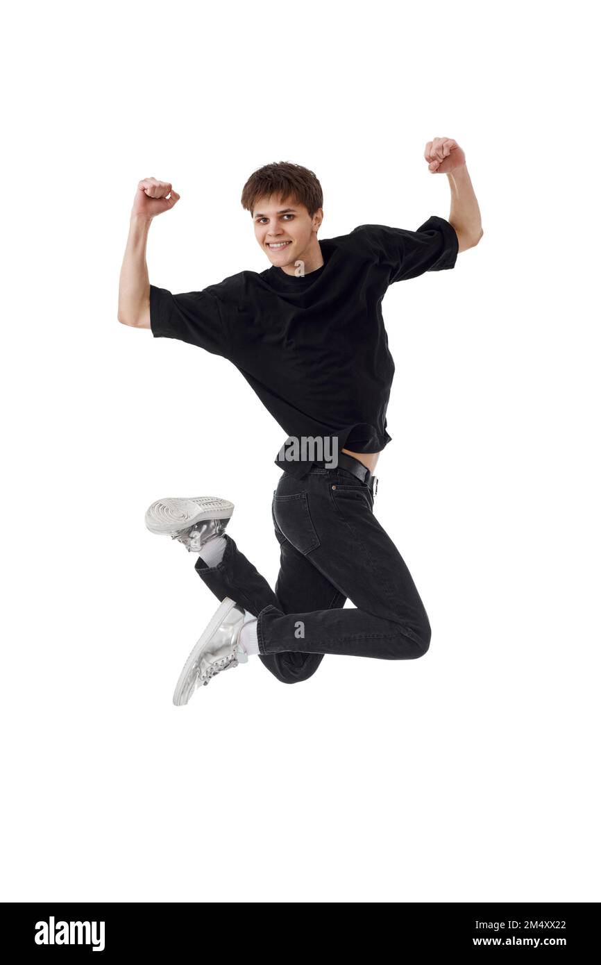 young man in black t-shirt smiling jumping high Stock Photo