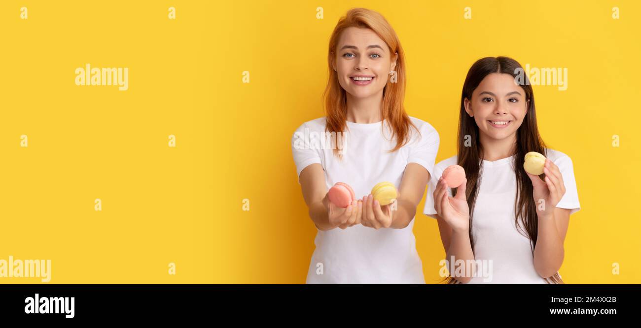 Mother and daughter kid banner, copy space, isolated background. happy family of woman and teen girl hold french macaron cookies, french macaroon. Stock Photo