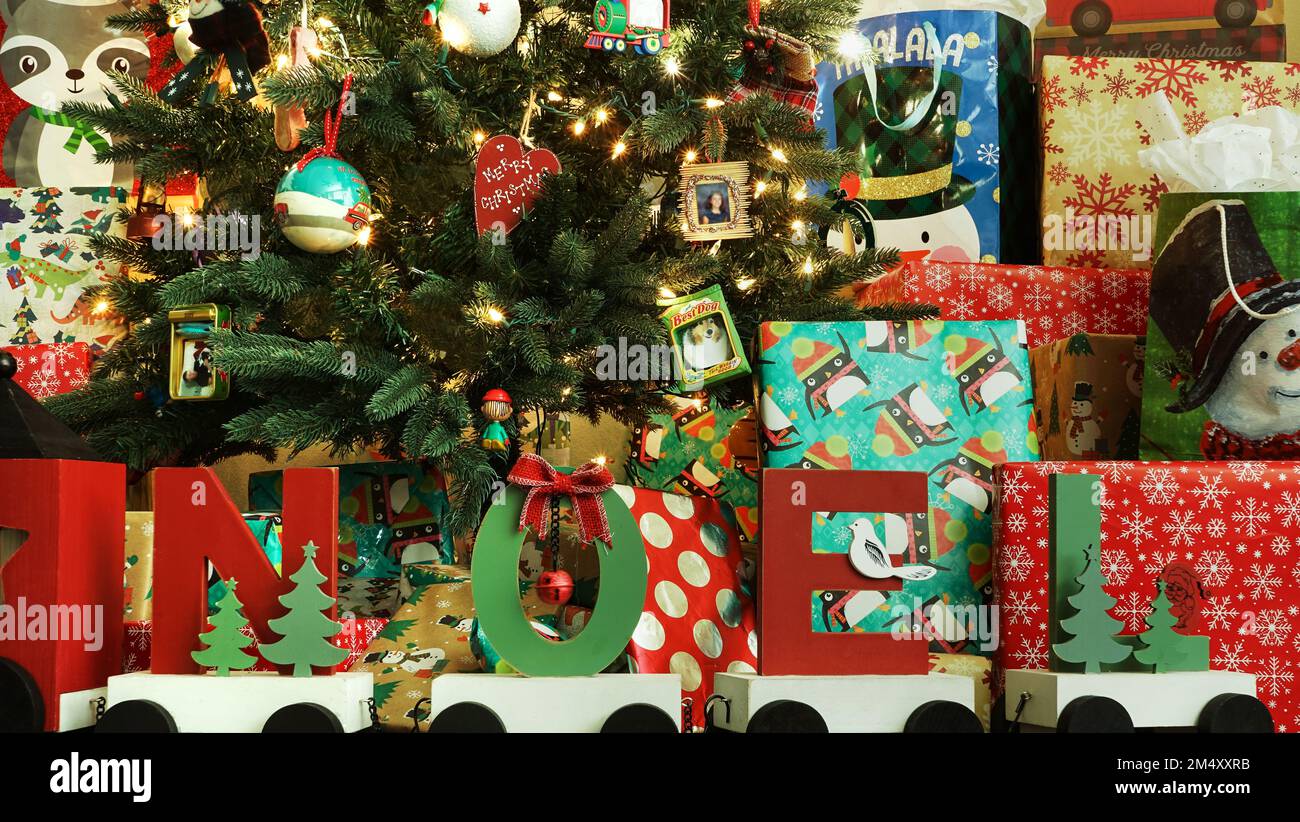Presents cluttered under the Christmas tree on floor Stock Photo