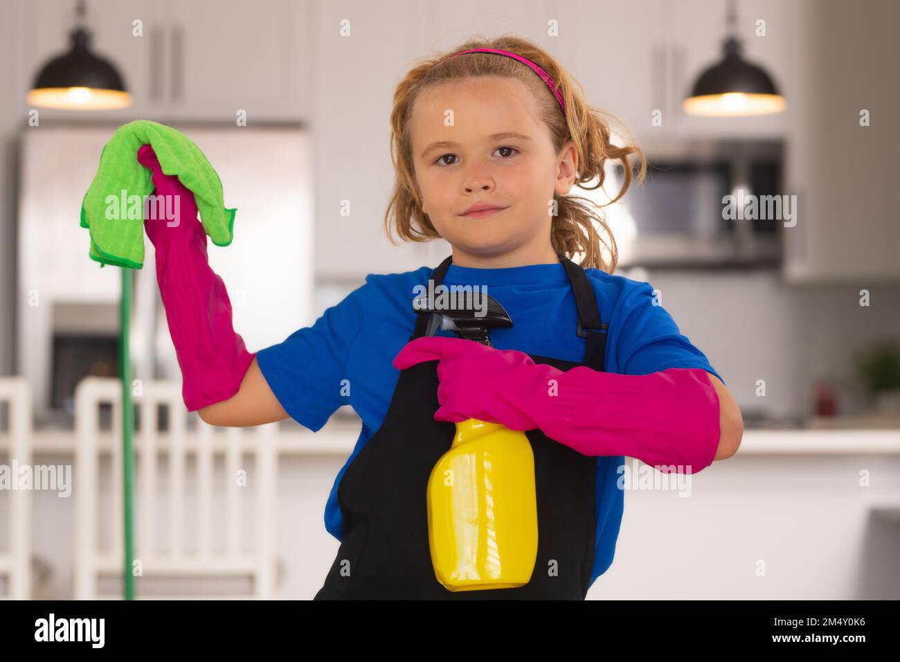 Cleaning house. Child use duster and gloves for cleaning. Funny child mopping house. Stock Photo