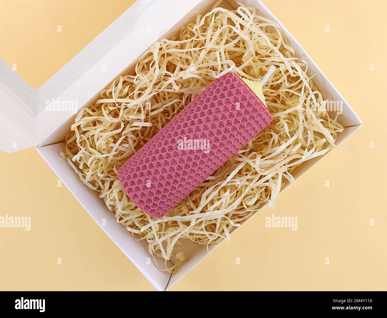 Large handmade candle made of natural wax sheet. Artificial straw for