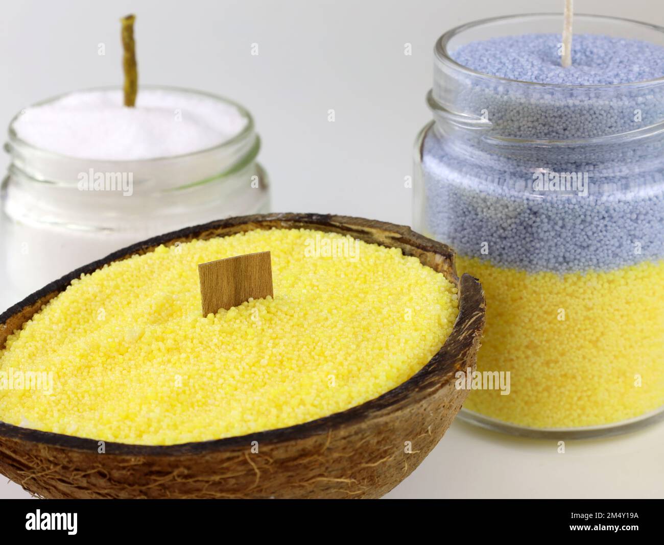 Yellow bulk candles in coconut with a wooden wick. Candles in a jar