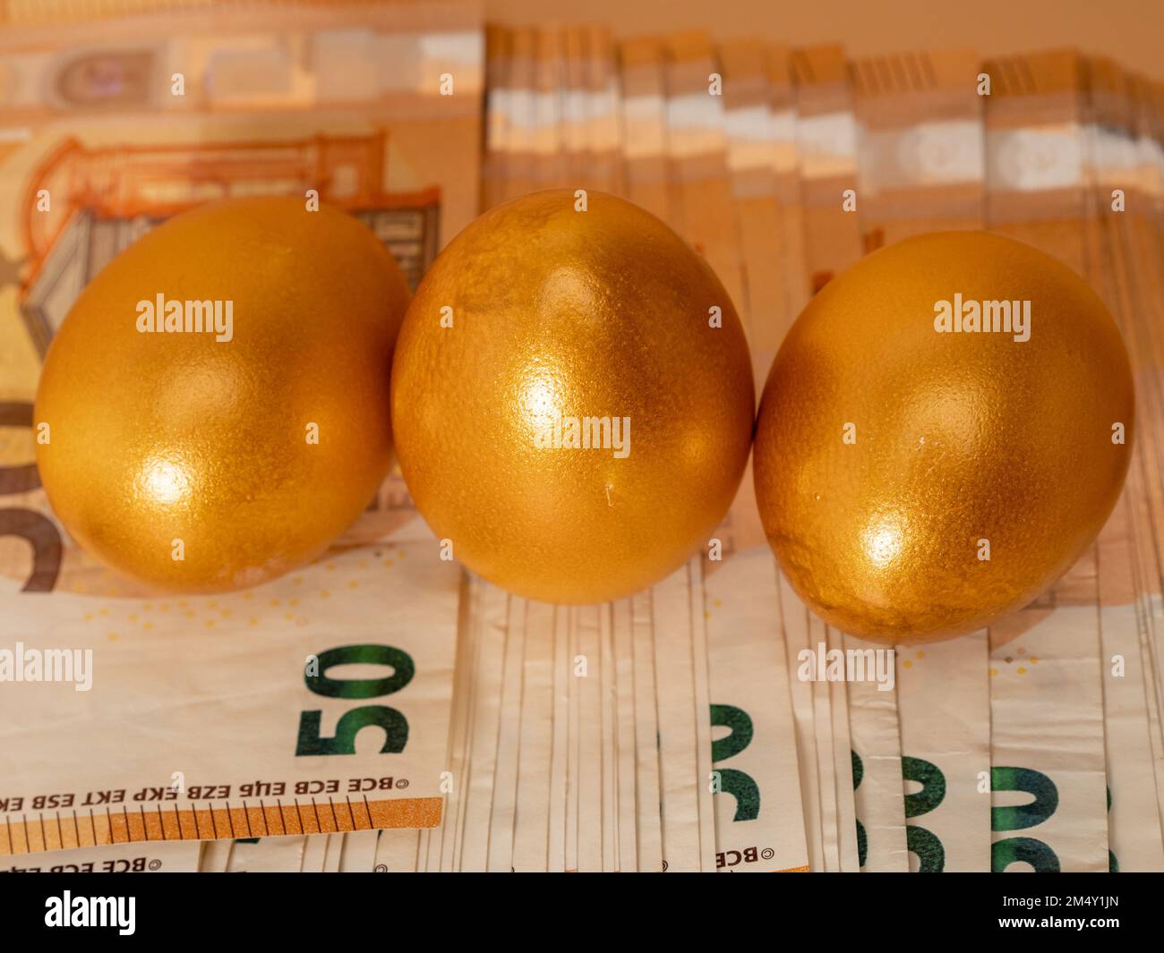 Golden eggs. A symbol of making money and successful investment on green  background Stock Photo - Alamy