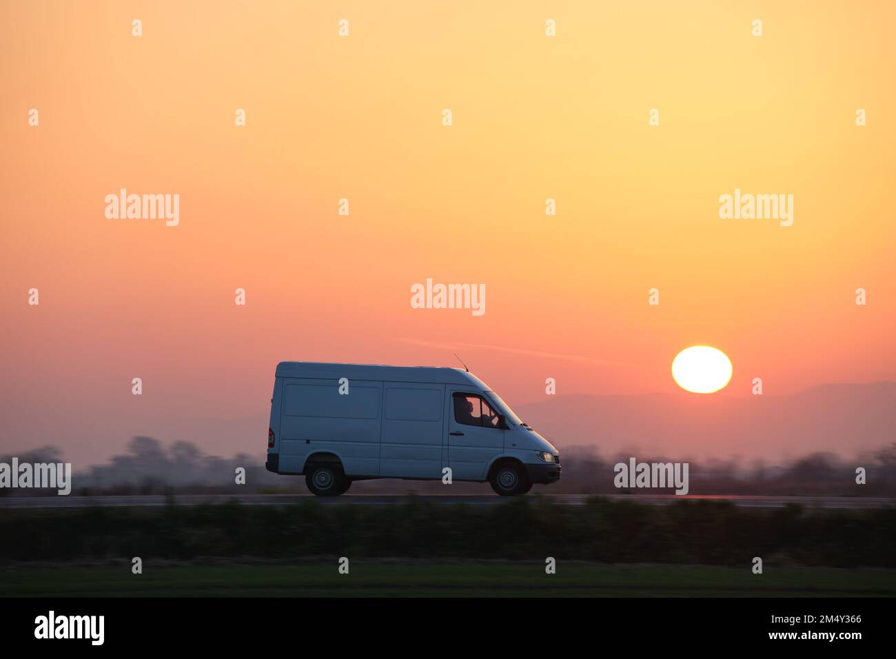 Small cargo van driving on highway hauling goods. Delivery