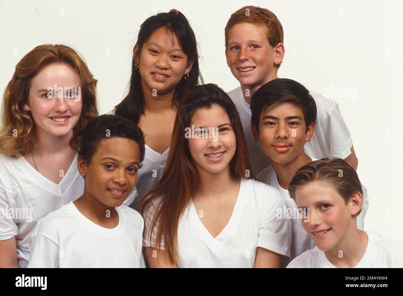 Group of 7 teens all in white t-shirts posing for a picture Stock Photo