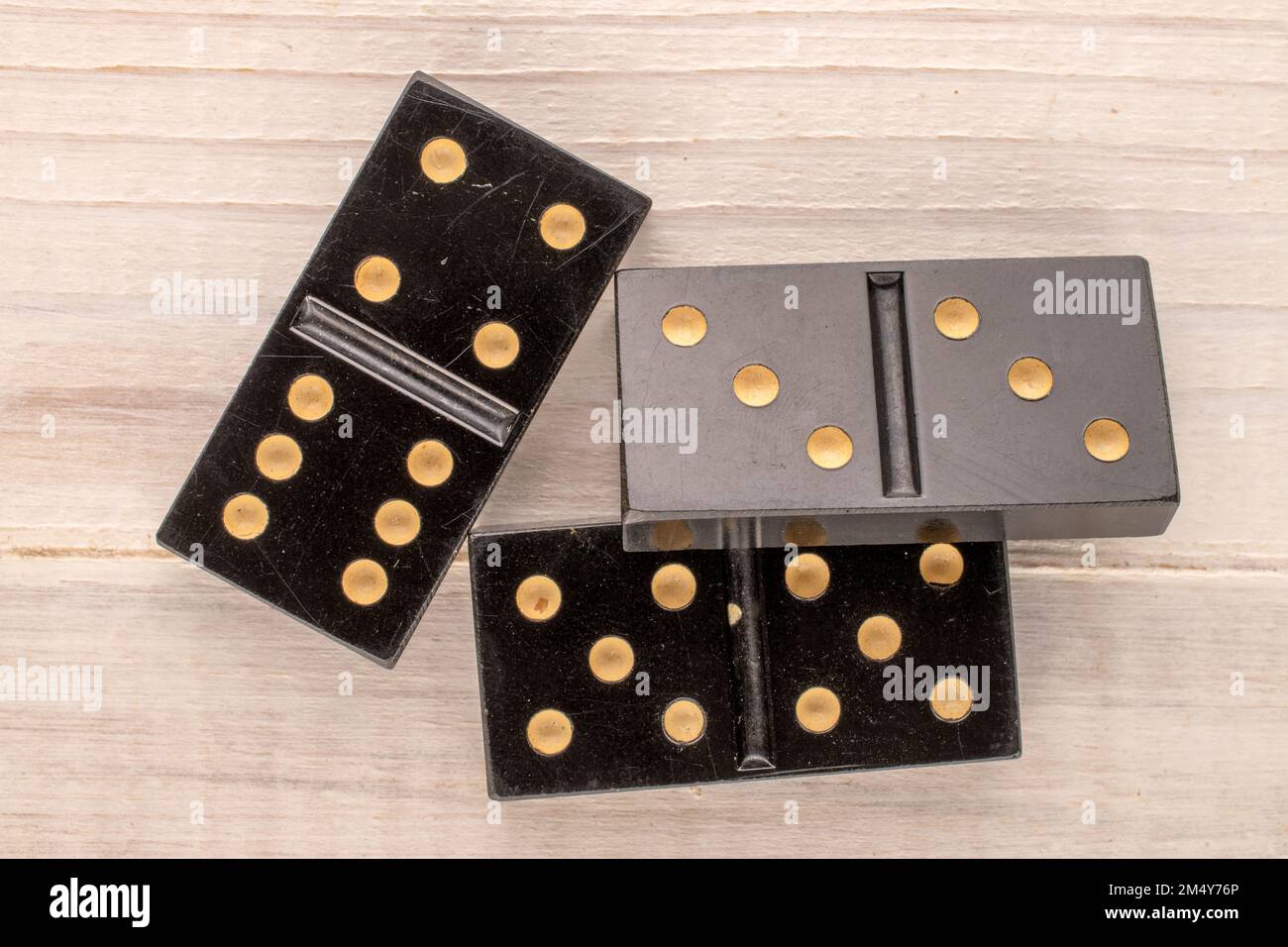 Three dominoes on a wooden table, macro, top view. Stock Photo