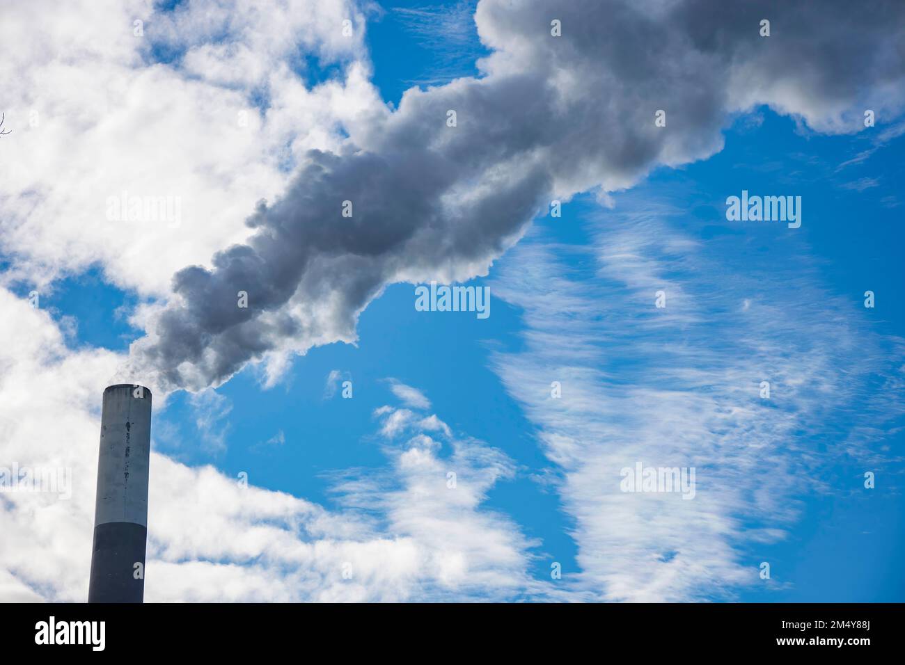 Industrial chimney, thermal power plant, pollution in the air, steam cooling tower in Graz, Styria region, Austria. Stock Photo
