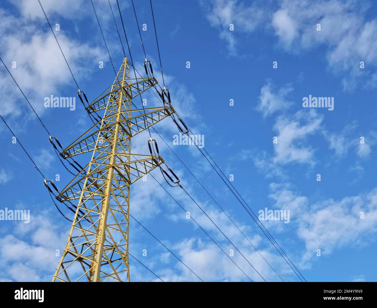 High voltage electric pole and power lines, high voltage electric transmission tower and blue cloudy sky Stock Photo