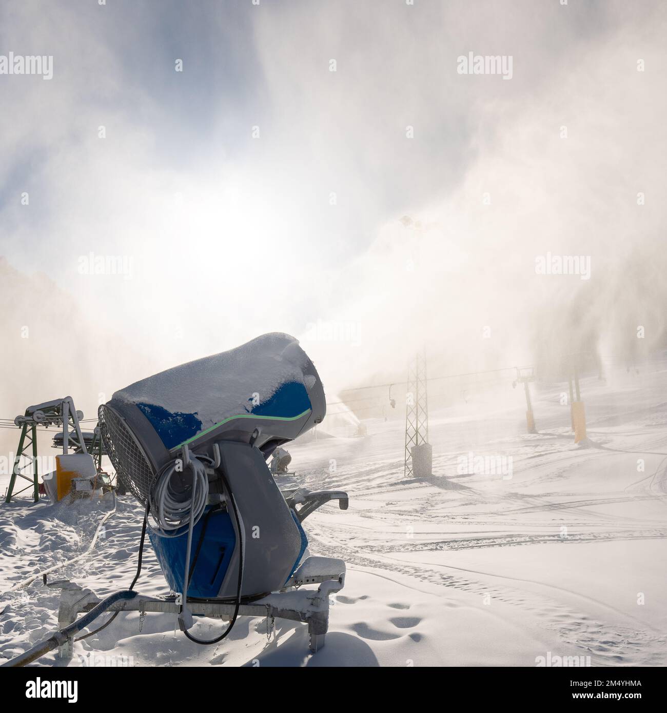 Snowmaking machine snow cannon or gun in action on a cold sunny winter day in ski resort Kranjska Gora, Slovenia Stock Photo