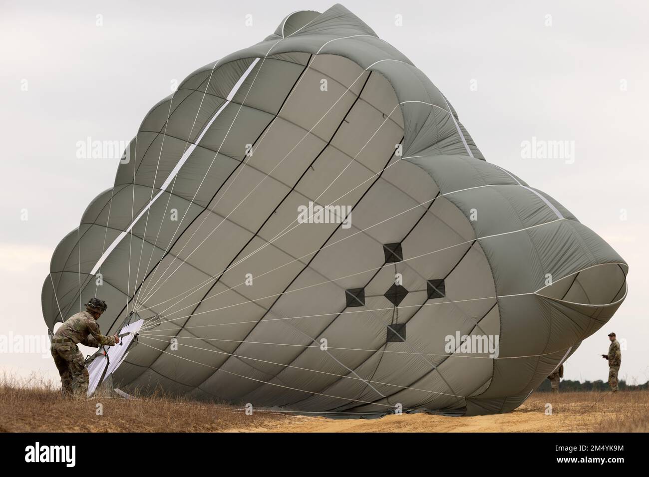 Fort Bragg, North Carolina, USA. 8th Dec, 2022. A U.S. Soldier packs his parachute after jumping from a KC-130J Hercules assigned to Marine Aerial Refueler Transport Squadron (VMGR) 252 at Fort Bragg, North Carolina, December. 8, 2022. Randy Oler Memorial Operation Toy Drop 2.0 is an event hosted by the U.S. Army Civil Affairs and Psychological Operations Command (Airborne) in conjunction with Fort Bragg and partner nations' airborne organizations to increase joint-airborne interoperability and conduct community outreach. VMGR-252 is a subordinate unit of 2nd Marine Aircraft Wing, the a Stock Photo