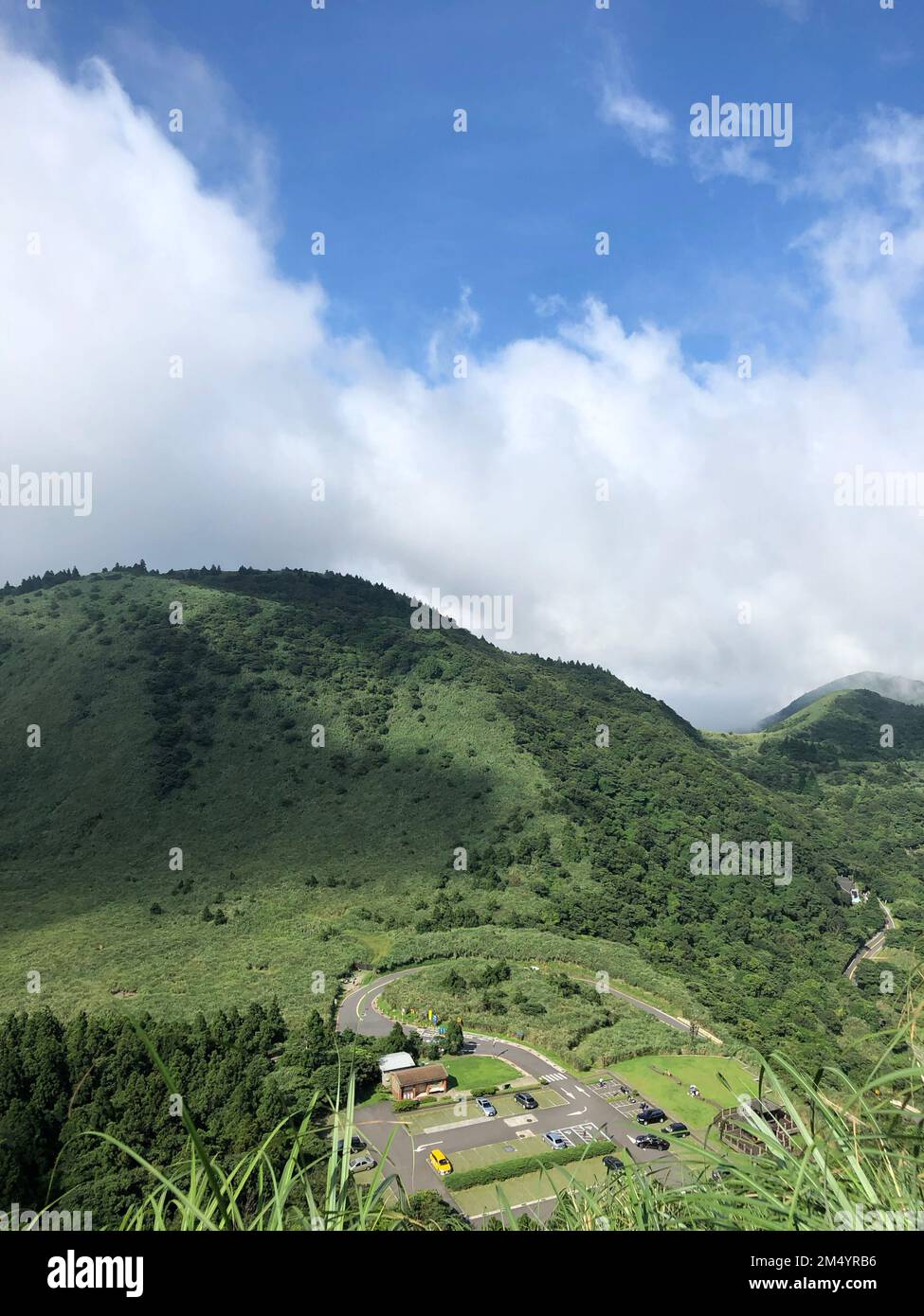 A vertical shot of Qixing Mountain in China surrounded by green trees and grass Stock Photo