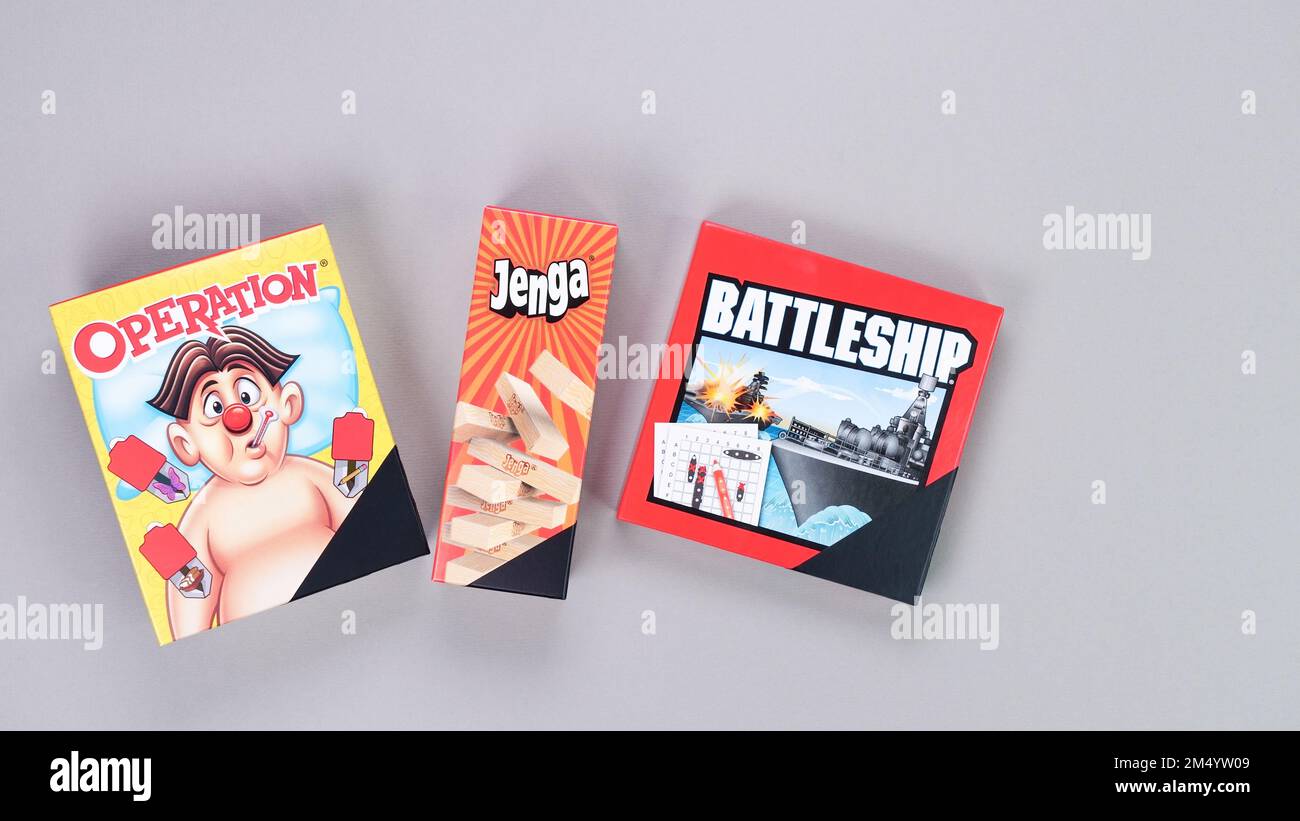 Mini board games on grey background. Fun games to play with kids. Boxes of Operation, Jenga, Battleship games. Gatineau, QC Canada - 12-23-2022 Stock Photo