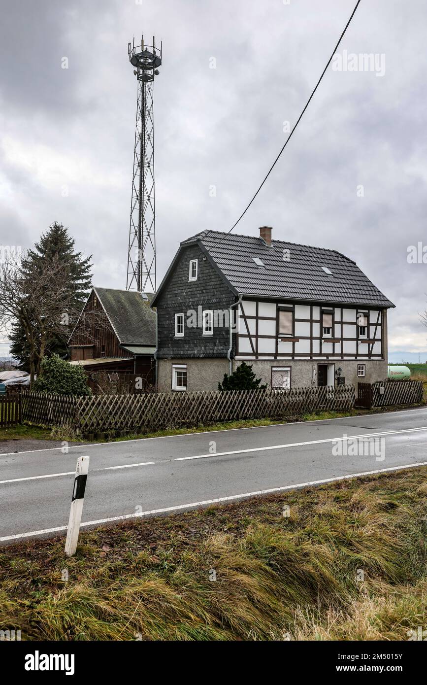 Hohenstein Ernstthal, Germany. 22nd Dec, 2022. A radio mast for the mobile  network stands behind a small homestead. A survey by the Left Party deals  with the radio holes in Saxony. Credit: