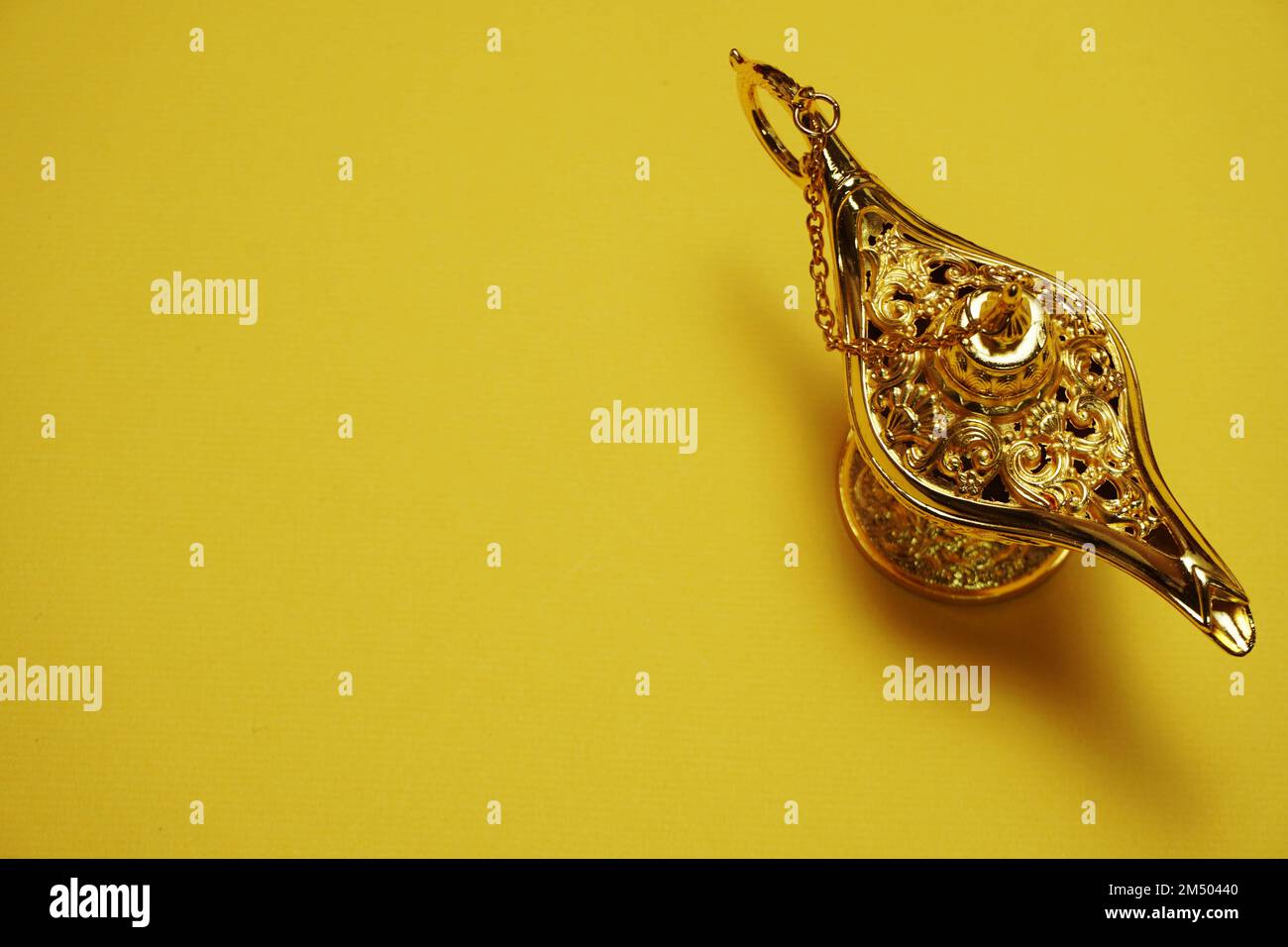 golden magic lamp with space copy on yellow background Stock Photo