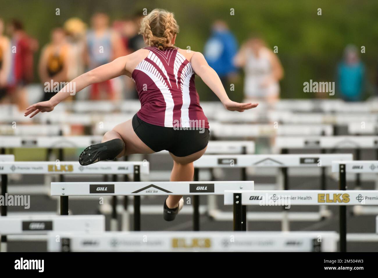 A scenic view of a Female athlete competing in the hurdle event at a