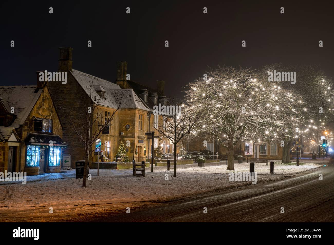 Christmas lights along the high street at night in the snow. Broadway