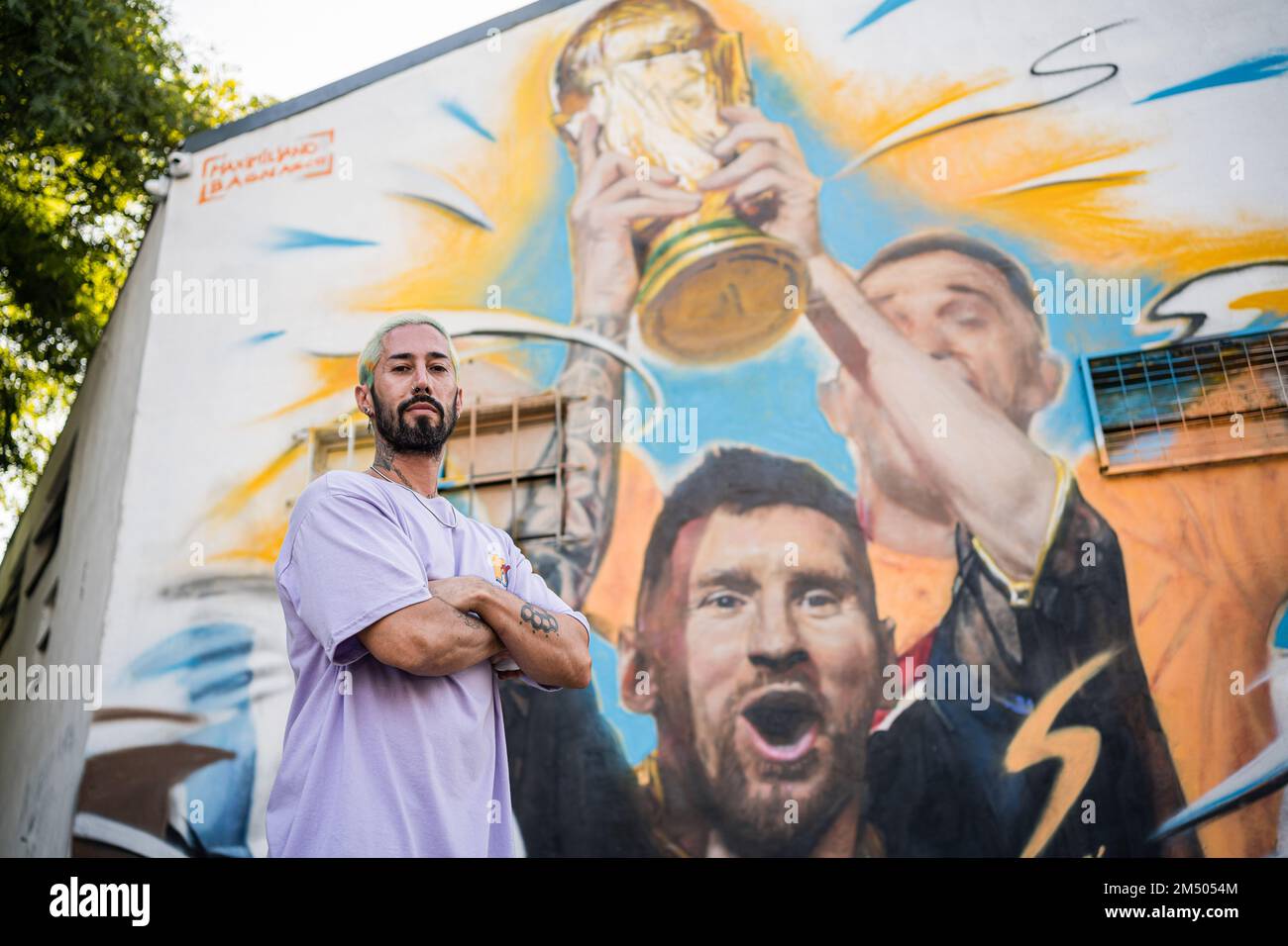 Buenos Aires, Argentina. 23rd Dec, 2022. The artist, Maximiliano Bagnasco, poses in front of his work in Buenos Aires. The Argentine artist, Maximiliano Bagnasco is the first to capture Argentina's triumph in Qatar 2022 in a mural where Lionel Messi is seen lifting the FIFA World Cup in the Palermo neighborhood, Buenos Aires. Credit: SOPA Images Limited/Alamy Live News Stock Photo