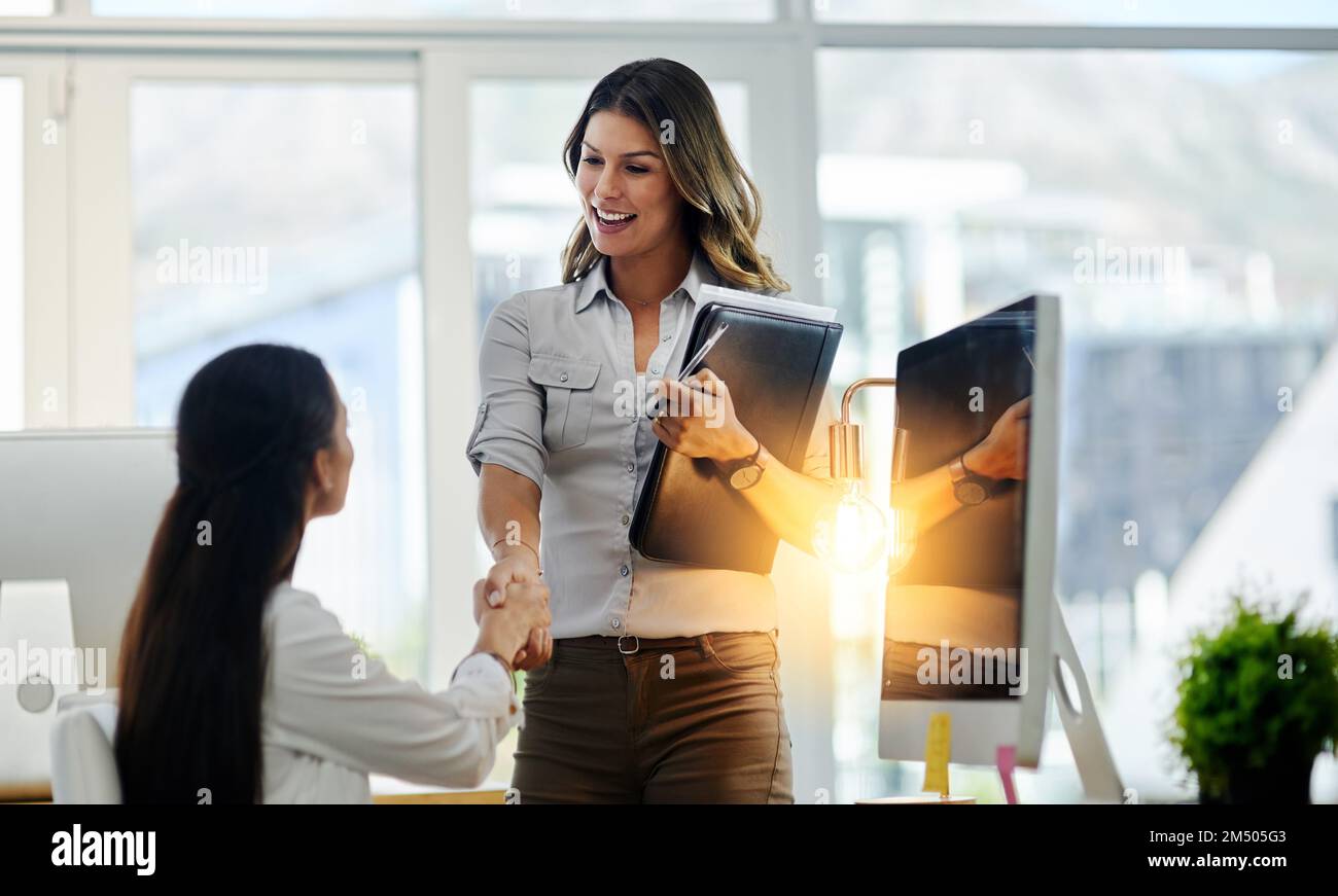 Thank you for your time. two young business women greeting each other with a handshake in the office at work. Stock Photo