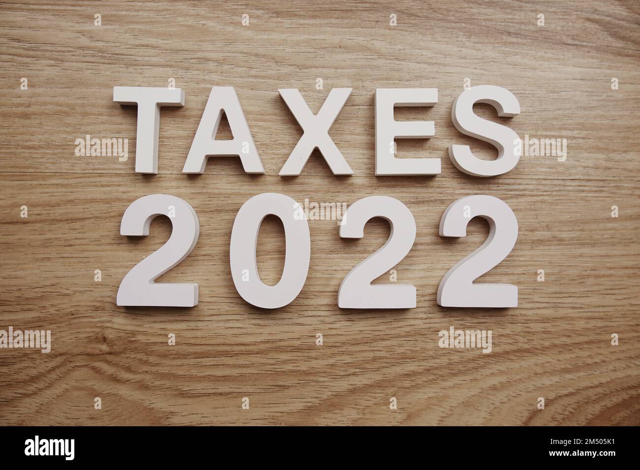 Taxes 2022 alphabet letters on wooden background Stock Photo