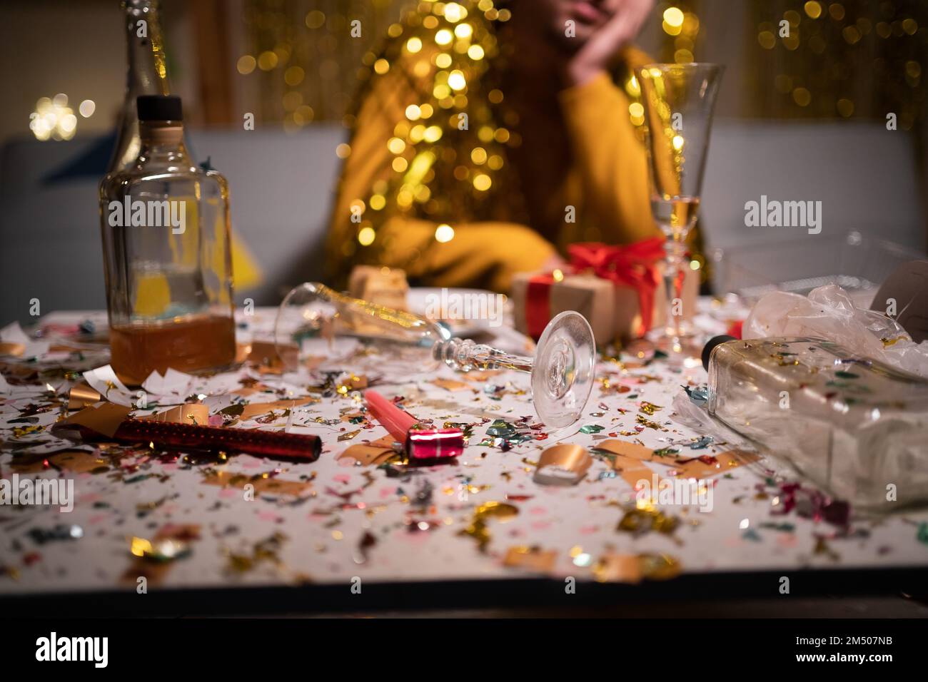 Messy table after party and sitting blurred man in background. Copy space Stock Photo