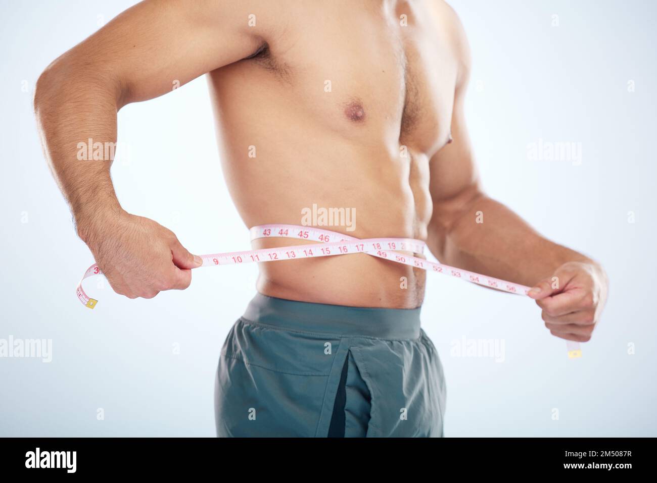 Image of muscular man measure his waist with measuring tape in centimeters  Stock Photo - Alamy