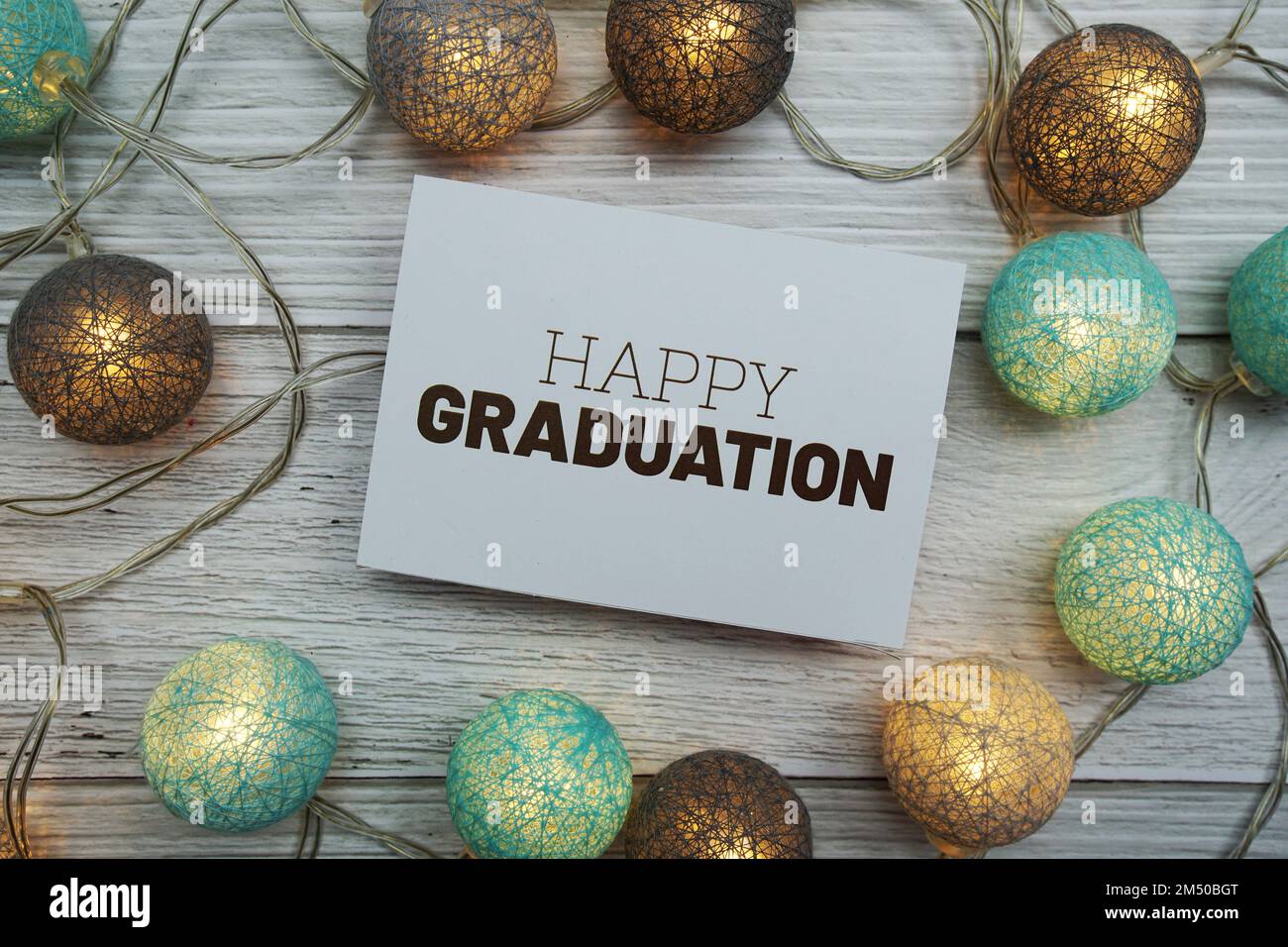 Happy Graduation text on paper card with LED cotton balls top view on ...