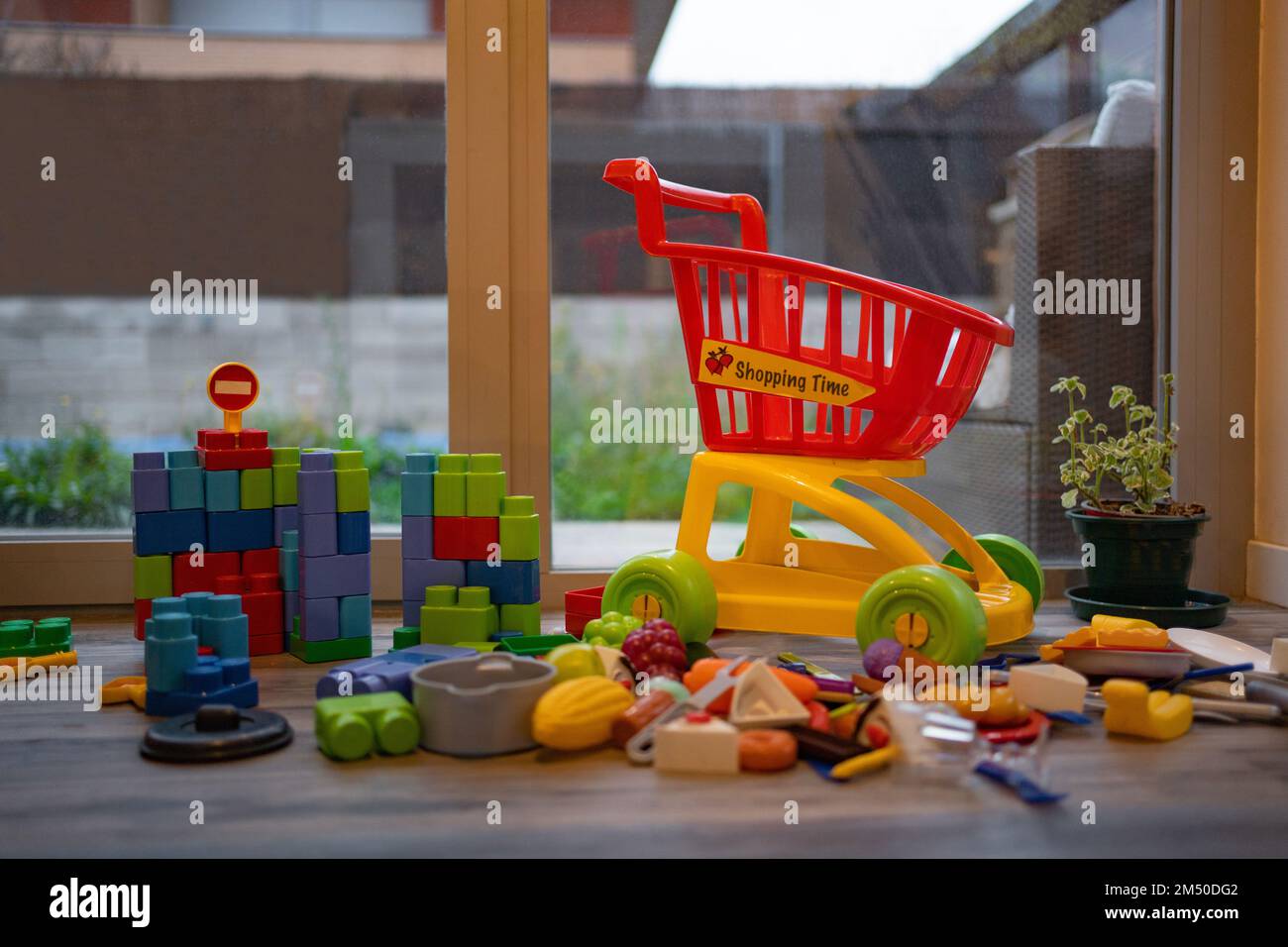 Adorable toddlers playing among the many toys at home. A mess in the